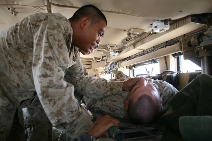 Seaman Efren Estrada, a corpsman with Task Force 2nd Battalion, 2nd Marines, Regimental Combat Team 5, examines a simulated casualty inside a new Mine Resistant Ambush Protected Ambulance at Camp Al Qaâ??im, Iraq, August 15. After the manufacturers of the MRAP redesigned the standard equipment layout, the MRAP Ambulance has vital sign machines, hydraulic litter skids, suction machines and medical supply kits.
