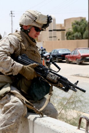 Lance Cpl. Michael Stangelo, a rifleman with Company F, Task Force 2nd Battalion, 2nd Marines, Regimental Combat Team 5, climbs a barrier while en route to the civic center in Rawah, Iraq, August 17. Marines with Company F have moved out of the city of Rawah, but still patrol the streets of the city to assist the Iraqi Security Forces.::r::::n::::r::::n::
