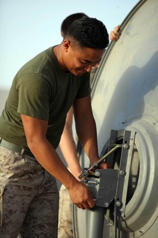 CAMP BARBER, Afghanistan – Corporal Mikael S. Satini, a switchboard operator attached to Communications Platoon, Task Force 2d Battalion, 7th Marine Regiment, 1st Marine Division, and Bueno Park, Calif., native, installs a satellite dish to expand communications at a forward operating base. (U.S. Marine Corps photo by Cpl. James M. Mercure)