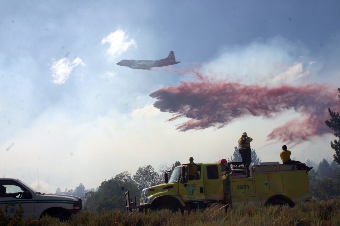 Carson City Bureau of Land Management firefighters watch as a P-2V Neptune drops retardant on the fire aboard Marine Corps Mountain Warfare Training Center in Bridgeport, Calif., Aug. 18, 2008. The fire, started by lightning, burned 680 acres of land before it was contained.
