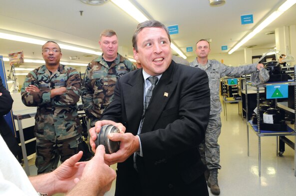 Michael Mehrman, Financial Management Directorate director, reacts to the powerful torque produced by an N-1 directional gyro motor during a tour of the gyro shop by the AFSO21 senior leaders course group. U. S. Air Force photo by Sue Sapp