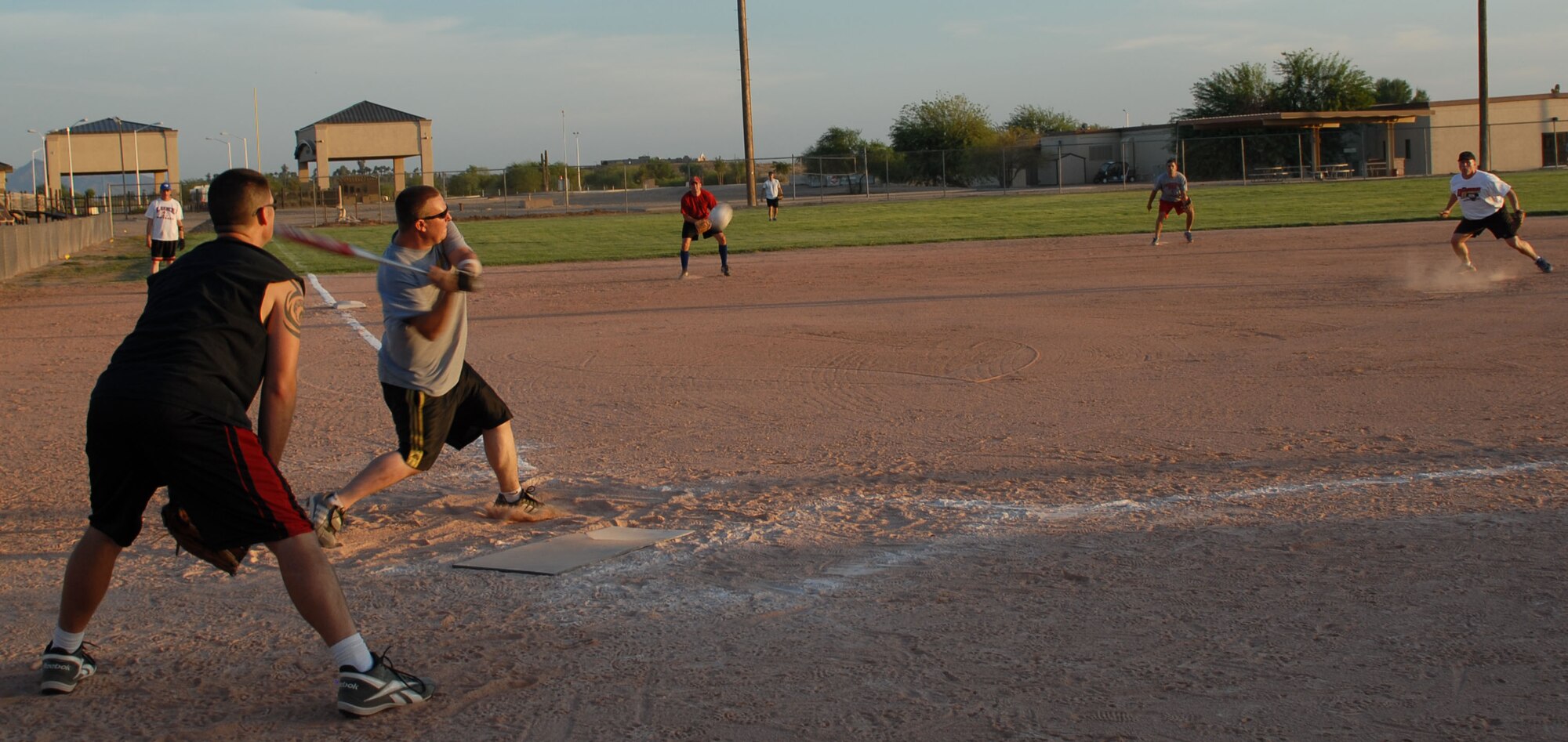Jeff Martell, 56th Aircraft Maintenance Squadron second baseman, swings at a pitch from Marty Lund, 56th Logistics Readiness Squadron, as Richard Knick, 56th LRS, stands ready to catch, during the intramural softball championship Monday. LRS defeated AMXS 15-11 after seven innings of play.
