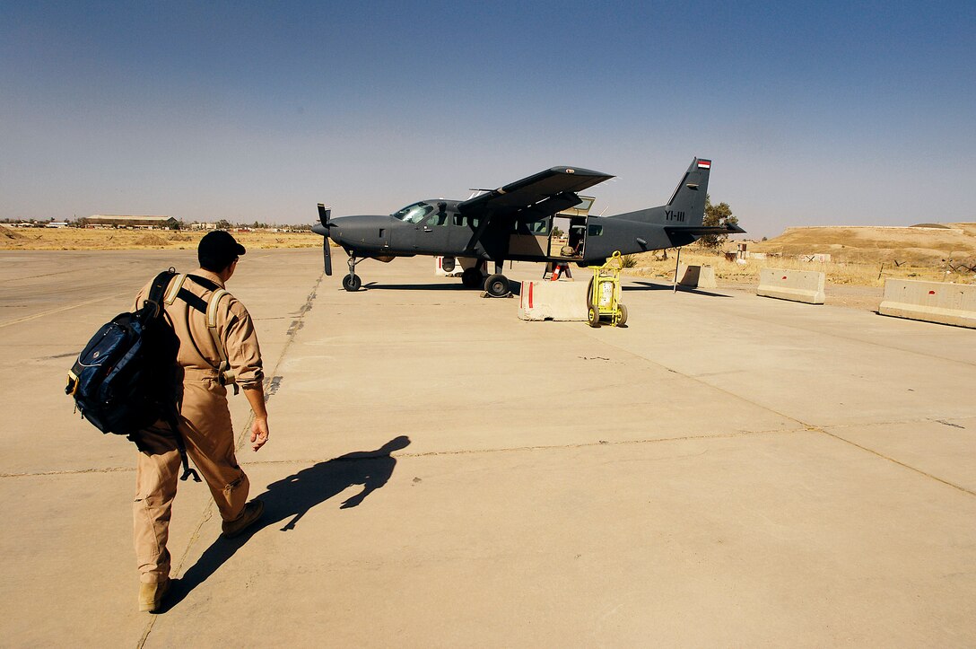 An Iraqi pilot walks to a Iraqi C-208 Cessna Caravan for his last training ride with U.S Air Force Lt. Col. Terry Wheeler from the 870th Air Expiditionary Advisory Squadron Kirkuk Regional Air Base, Iraq, July 19. Colonel Wheeler is an instructor pilot training Iraqi pilots to fly the C-208 Cessna Caravan. The Caravan is equipped with a surveillance package for intelligence surveillance and reconnaissance work. (U.S. Air Force photo/Staff Sgt. Aaron Allmon)