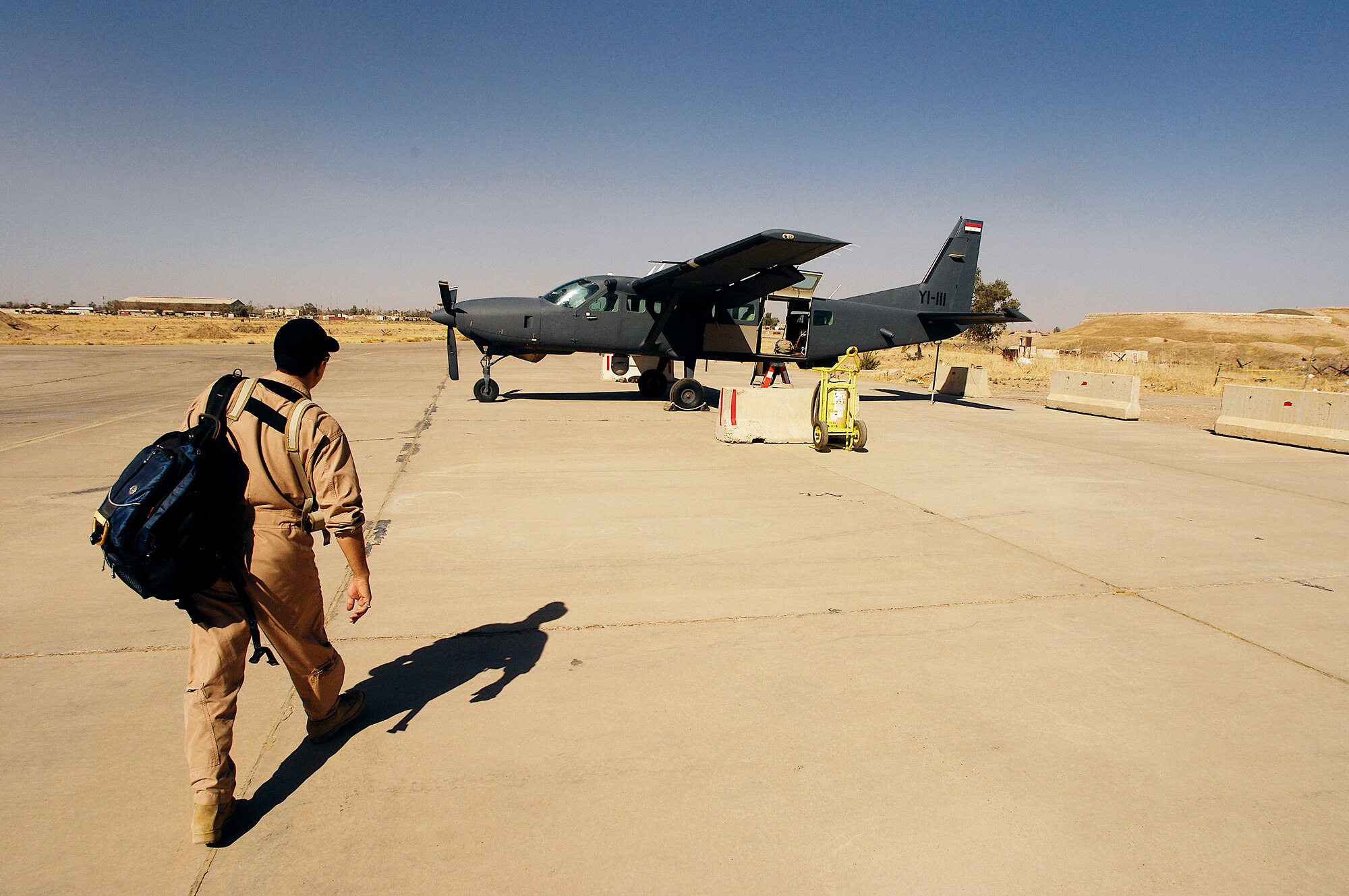 An Iraqi pilot walks to a Iraqi C-208 Cessna Caravan for his last training ride with U.S Air Force Lt. Col. Terry Wheeler from the 870th Air Expiditionary Advisory Squadron Kirkuk Regional Air Base, Iraq, July 19. Colonel Wheeler is an instructor pilot training Iraqi pilots to fly the C-208 Cessna Caravan. The Caravan is equipped with a surveillance package for intelligence surveillance and reconnaissance work. (U.S. Air Force photo/Staff Sgt. Aaron Allmon)