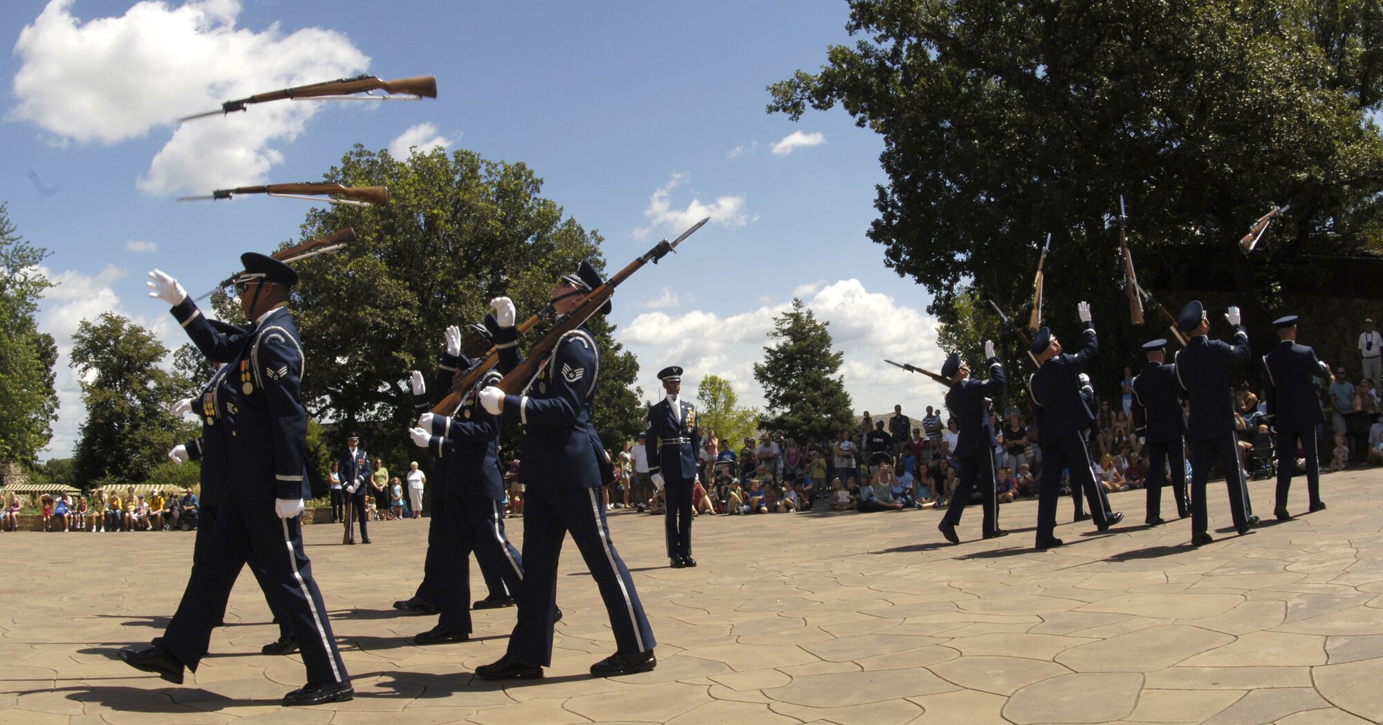 Members of the U.S. Air Force Honor Guard Drill Team throw "Marching Toss Backs" during their 12-man routine at Henry Doorly Zoo, Aug. 12 in Omaha, Neb. The drill team is the traveling component of the Honor Guard and tours worldwide representing all Airmen while showcasing Air Force precision. (U.S. Air Force photo by Senior Airman Dan DeCook)