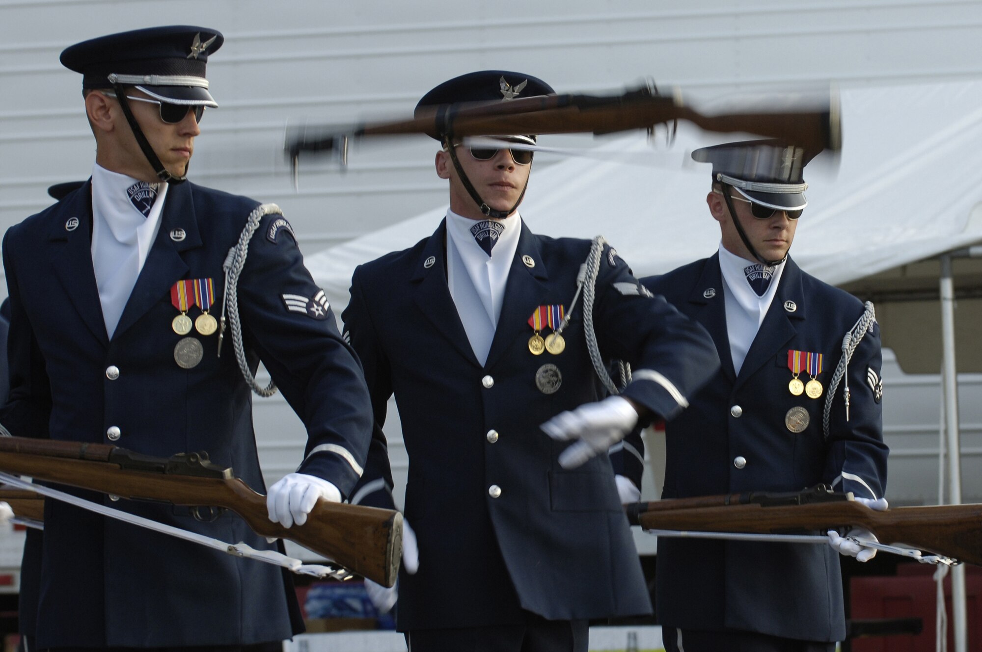 Senior Airmen James Floyd, Brandon Bridges and Joel Odegaard perform as part of a 12-man team at Mid-America Ribfest Aug. 14 in Council Bluffs, Iowa. The drill team is the traveling component of the Honor Guard and tours worldwide representing all Airmen while showcasing Air Force precision. (U.S. Air Force photo by Senior Airman Dan DeCook)