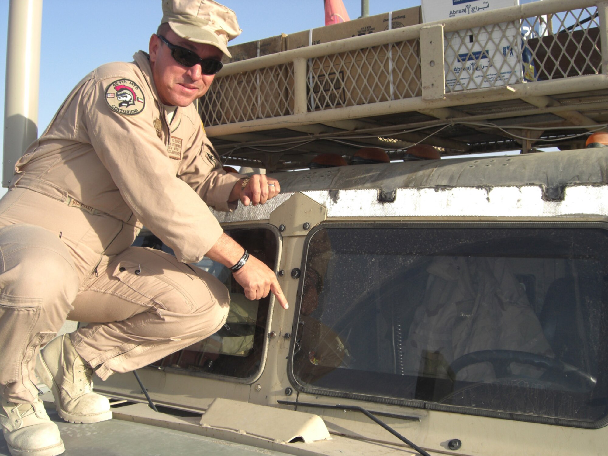 Chief Master Sgt. Rick Bunce, 100th Logistics Readiness Squadron chief enlisted manager, was chief of the 424th Medium Truck Detachment during his deployment to Iraq in 2007. During his deployment, his troops and vehicles came under attack many times. Here he points out where shrapnel went through two layers of bullet-proof glass on one of his trucks when it was hit by an improvised explosive device. (Courtesy photo)