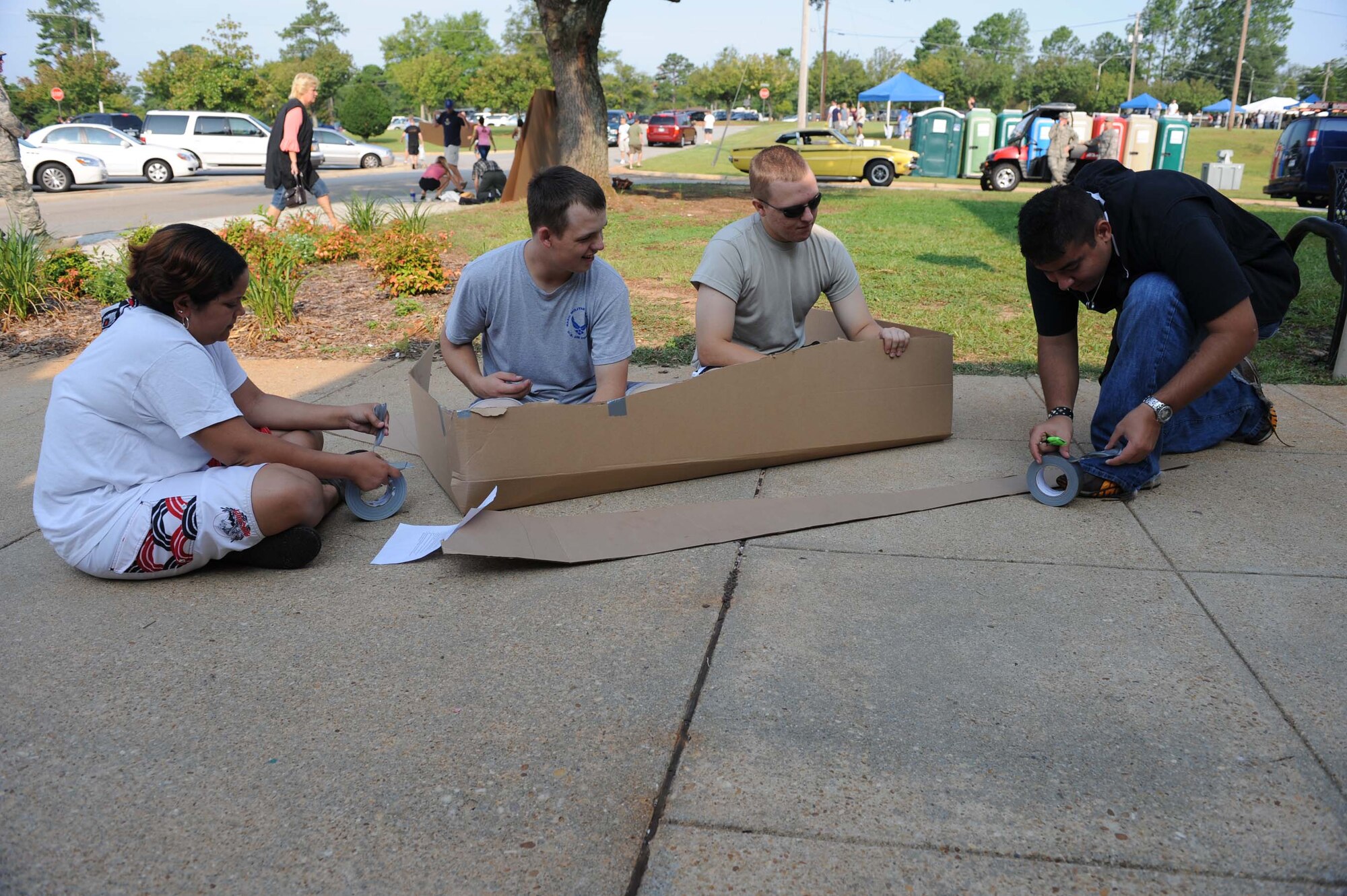 SHAW AIR FORCE BASE, S.C. -- Senior Airman Michelle Richardson, 77th Aircraft Maintenance Unit, Airman 1st Class Kyle Daves and Kenneth Herring, 20th Component Maintenance Squadron, and Airman Ramos Armando, 20th Dental Squadron, work on building a boat for the cardboard boat race during the Junior Enlisted Appreciation Day August 15. JEAD is a day full of fun events set aside to show appreciation for the junior enlisted ranks of the Air Force. (U.S. Air Force photo/Staff Sgt. Henry Hoegen)