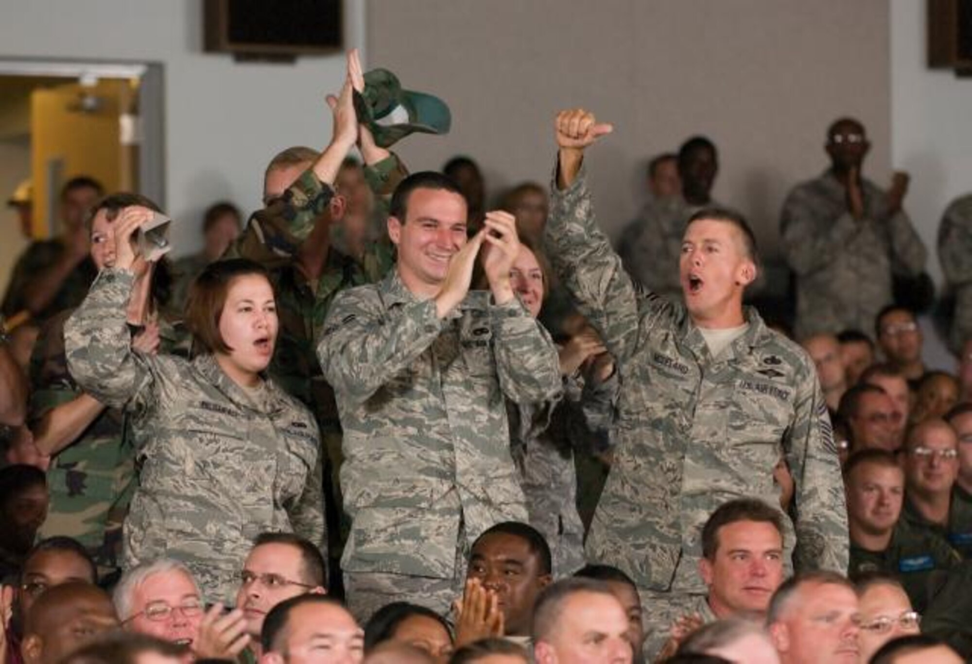 DOVER AIR FORCE BASE, Del. -- (Left to right) Senior Airman Stephanie Bilodeau, Airman 1st Class Nick Lander and Senior Master Sgt. Derek McLeland, 436th Aerial Port Squadron, applaud after being recognized as an outstanding team during the operational readiness inspection out-brief Aug. 14 at the Base Theater. Team Dover received an "Excellent" grade for their recent ORI in Alpena. Mich. (U.S. Air Force photo/ Jason Minto)