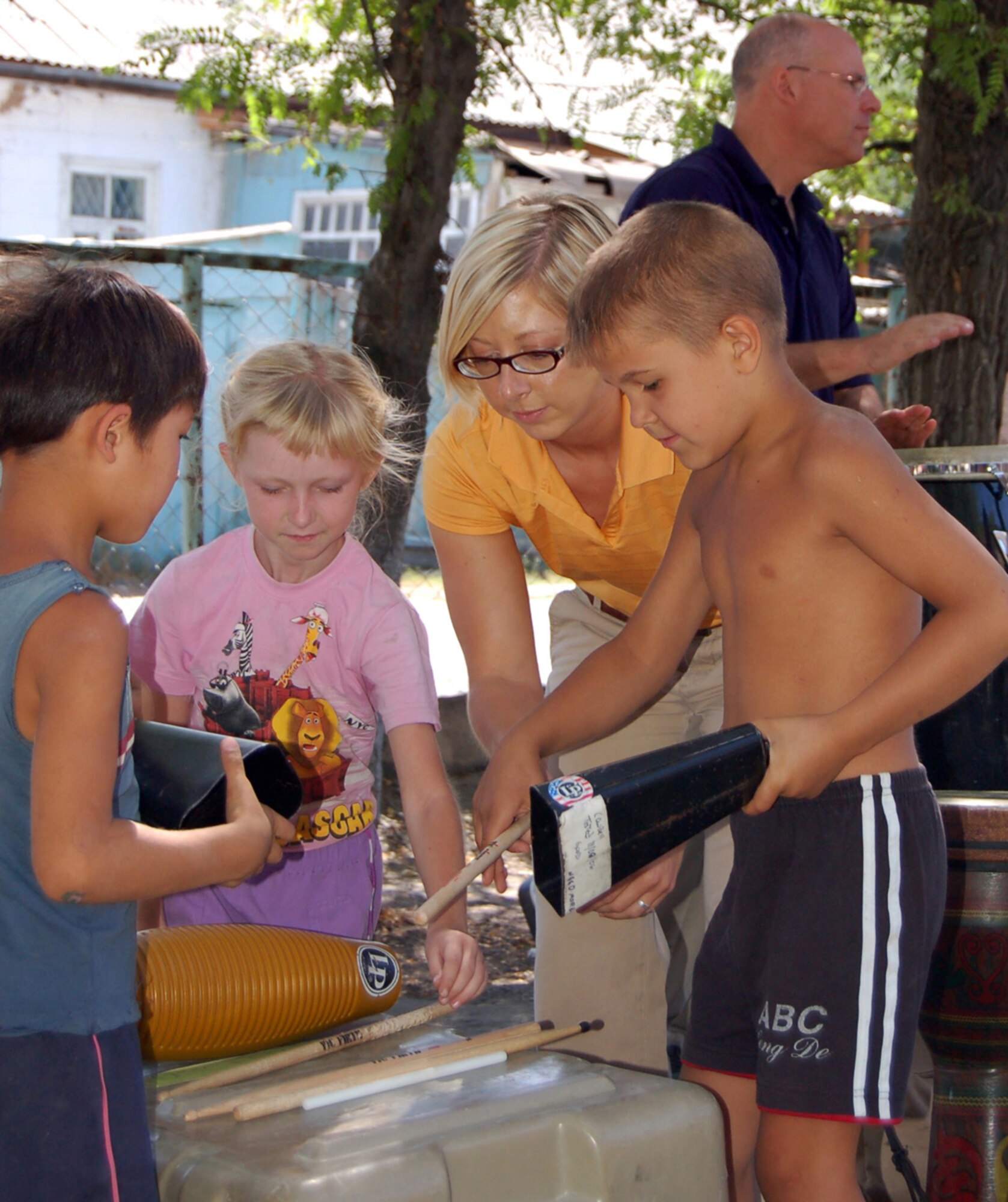 MANAS AIR BASE, KRYGYZ REPUBLIC--Staff Sgt. Traci Lamb, vocalist and saxaphonist with the Air Forces Central Band "Sirocco," passes out instruments to children during a performance at the Najesda Center Orphanage in the Kyrgyz Republic Capitol of Bishkek. The band was on a ten day tour to Manas AB where they played at eight schools, villages and orphanages as well as at the U.S. Embassy and on base. (Air Force photo / Senior Master Sgt. Patrick J. McCracken)
