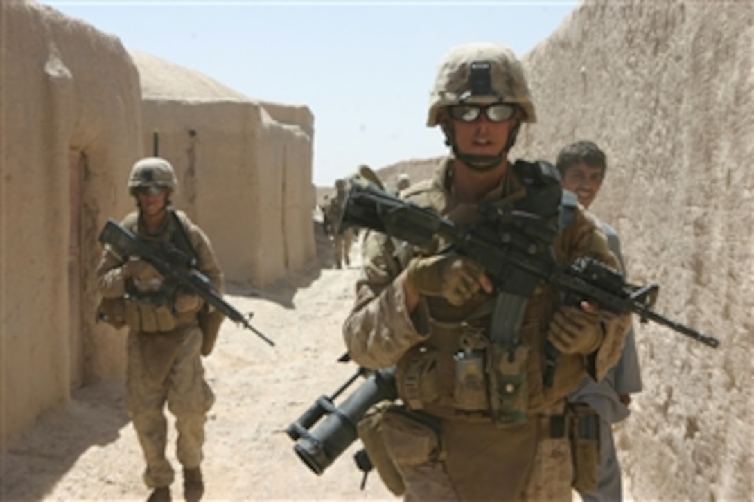 U.S. Marine Corps Lance Cpl. Jesse Lopez (left) and Lance Cpl. Brian Perez (right) conduct a dismounted patrol through the village outside of the forward operating base in the Bala Baluk District, Farah Province, Afghanistan, on July 25, 2008.  Lopez and Perez are both assigned to Golf Company, 2nd Battalion, 7th Marine Regiment.  