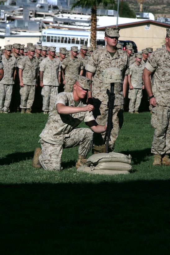 Lance Cpl. Jason Altmann, Company F, 2nd Battalion, 24th Marine Regiment, hangs the dog tags on the pistol grip for Cpl. Richard Nelson, who was killed in action April 14 in Iraq, during a memorial service Aug. 19 at Lance Cpl. Torrey L. Gray Field. Nelson and Lance Cpl. Dean Opicka were killed after their vehicle struck an improvised explosive device.