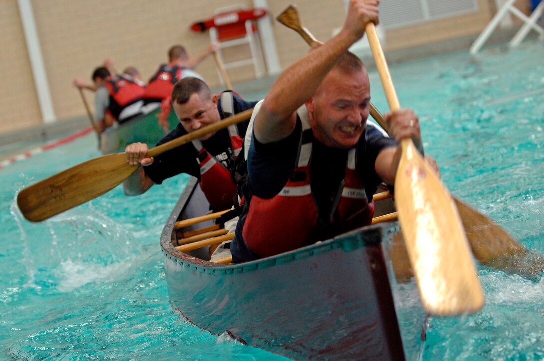 (Right) Tech. Sgt. Jason Kerkaert, 28th Civil Engineer Squadron pavement and equipments craftsman, paddles to victory with the help of his teammates in the canoe tug of war competition during the Ellsworth Olympic Picnic, Aug. 15, 2008.  This team from 28 CES took first place in this competition. (U.S. Air Force photo/Senior Airman Marc I. Lane)