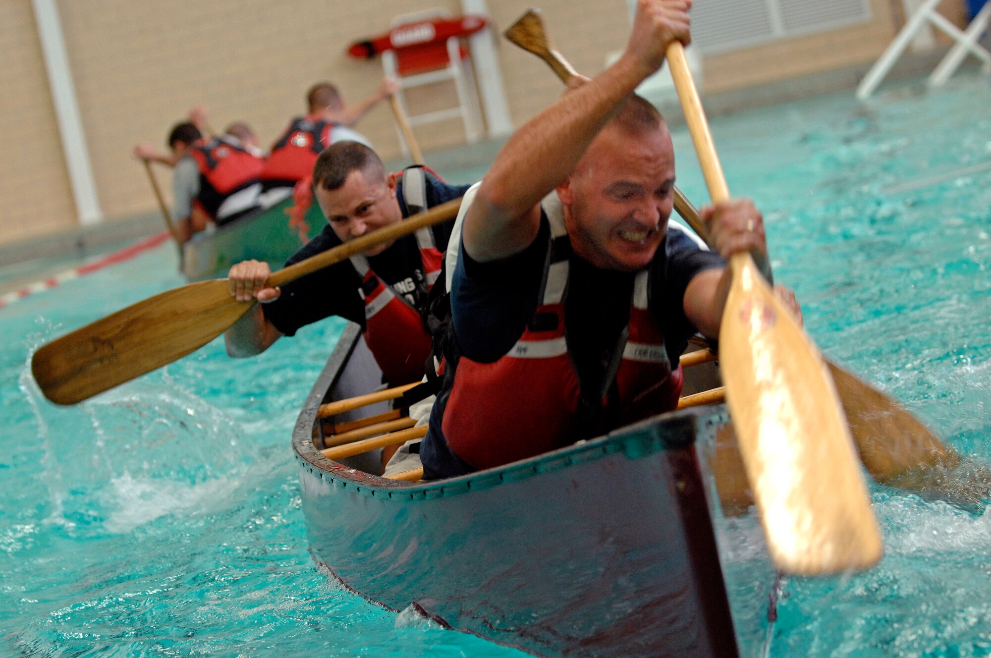(Right) Tech. Sgt. Jason Kerkaert, 28th Civil Engineer Squadron pavement and equipments craftsman, paddles to victory with the help of his teammates in the canoe tug of war competition during the Ellsworth Olympic Picnic, Aug. 15, 2008.  This team from 28 CES took first place in this competition. (U.S. Air Force photo/Senior Airman Marc I. Lane)