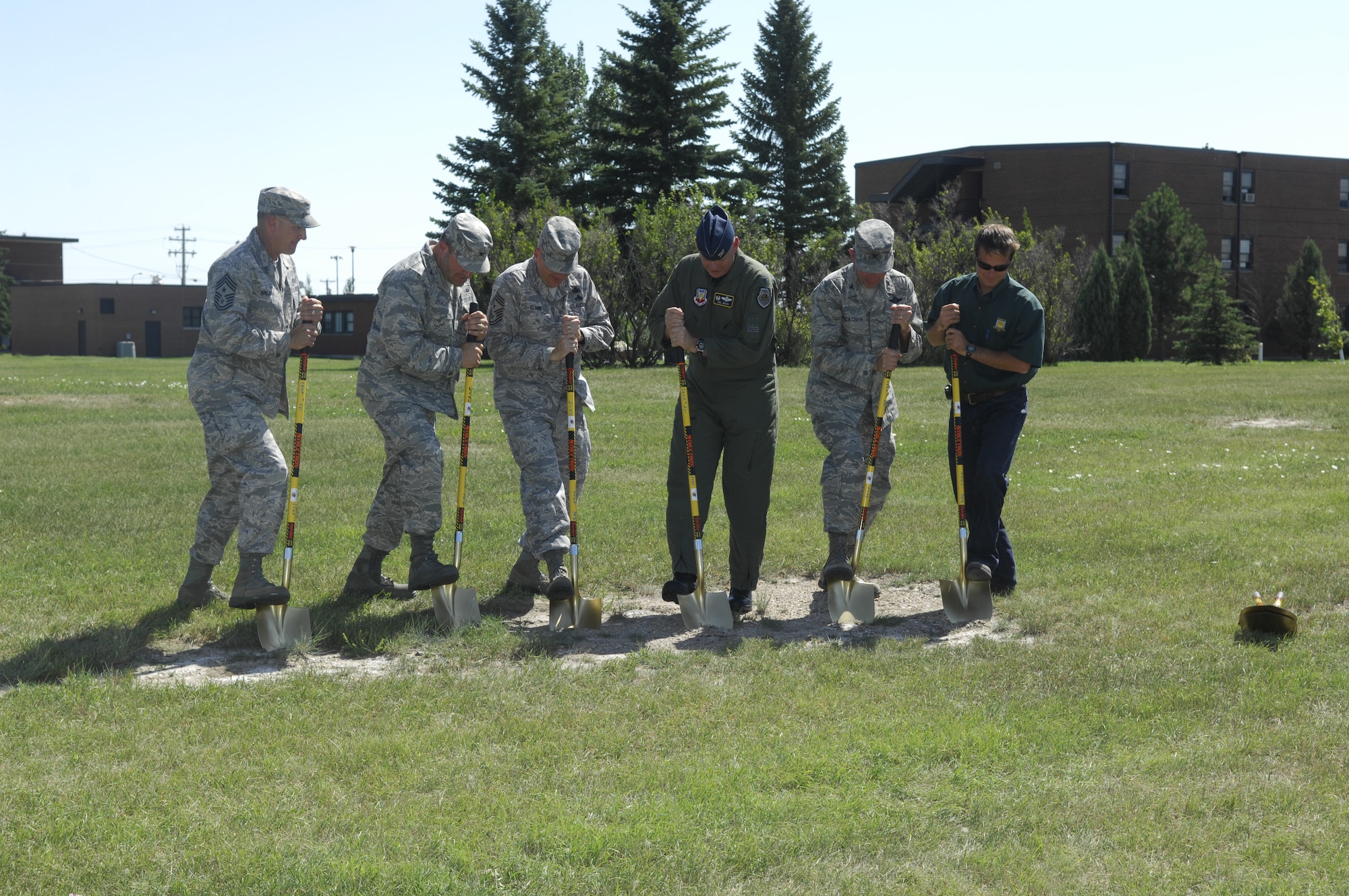 MINOT AIR FORCE BASE, N.D. – Col. Joel Westa (third from right), 5th Bomb Wing commander, and Col. Chris Ayres (second from left), 91st Missile Wing commander, break ground on the first dorm of the base’s dorm master plan here Aug. 19. Also participating in the ground-breaking were Col. James Gallagher (second from right), 5th Mission Support Group commander, Chief Master Sgt. Mark Brejcha (far left), 91st MW command chief master sergeant, Chief Master Sgt. Mark Clark (third from left), 5th BW command chief master sergeant, and Mike Comstock (far right), vice president of Comstock Construction. Overall, six dorms will be built to replace the current base dormitories, which were built between 1957 and 1975. (U.S. Air Force photo by Senior Airman Joe Rivera)
