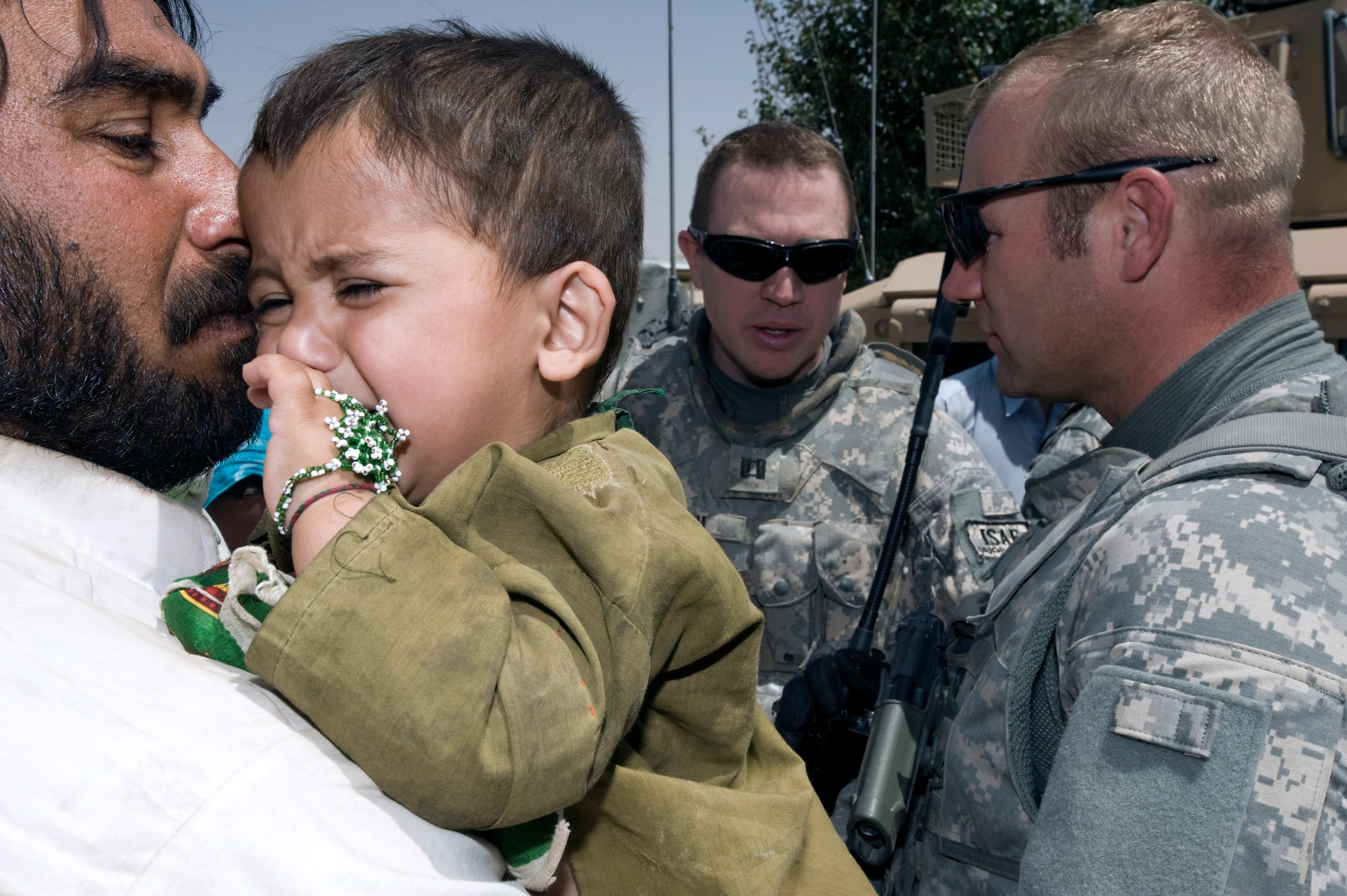Capt. Timothy Harrelson (center) and Army Maj. Trevor Nehls discuss care for a young Afghan boy who has a broken leg in Qalat, Afghanistan.  Captain Harrelson and Major Nehls are members of the Zabul Provincial Reconstruction Team.  (U.S. Air Force photo/ Master Sgt. Keith Brown)