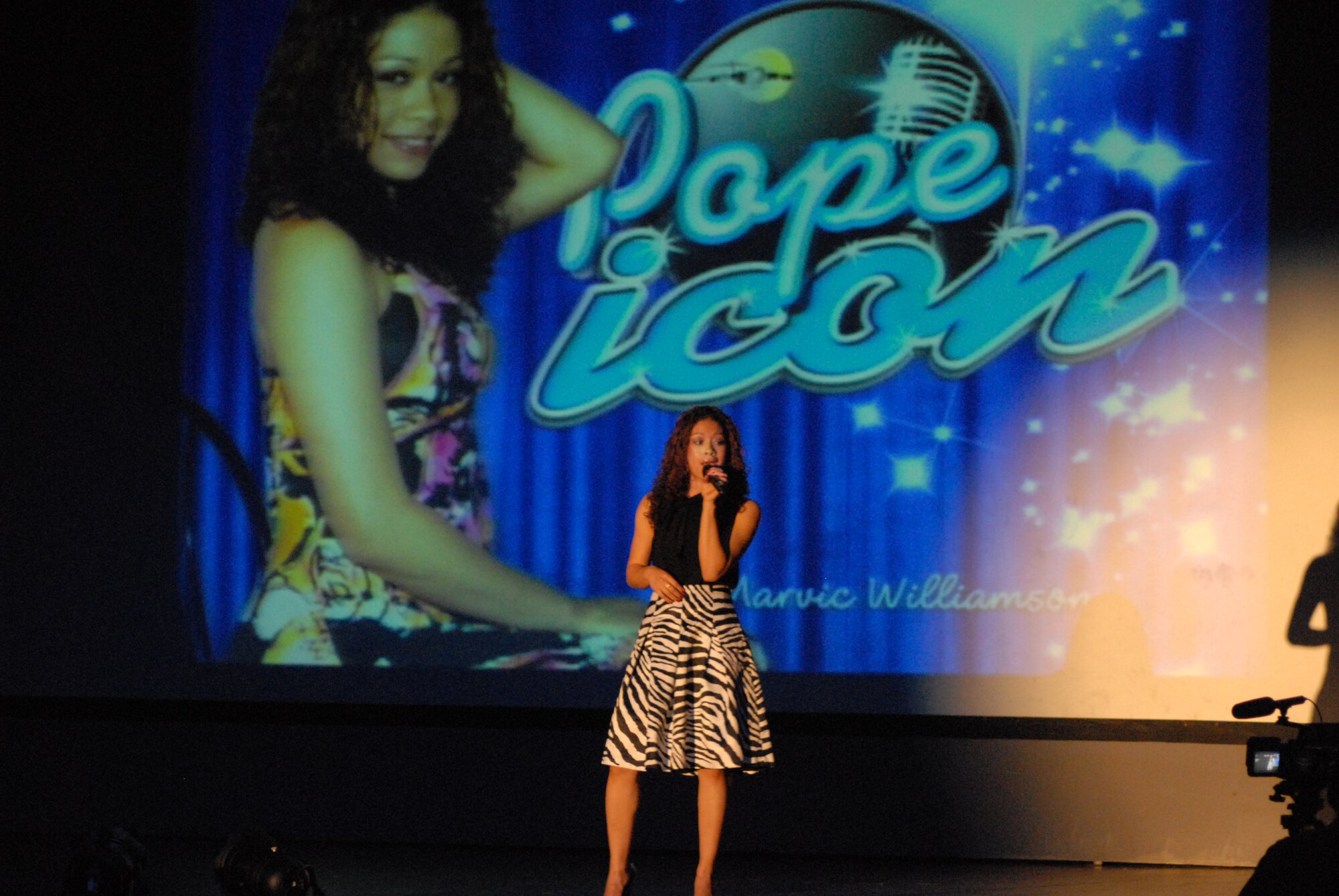 Staff Sgt. Marivic-Len Williamson, 43rd Airlift Wing, sings "Don't leave me this way" by Donna Summers during Pope Icon at the base theater Aug. 15. Sergeant Williamson sang "Break away" by Kelly Clarkson for her second song on her way to top nine other finalist and win the competition. She won $500 and will represent Pope at the Air Mobility Command Icon competition Oct. 23 at Scott Air Force Base, Ill. (U.S. Air Force Photo by Staff Sgt. Jon LaDue)