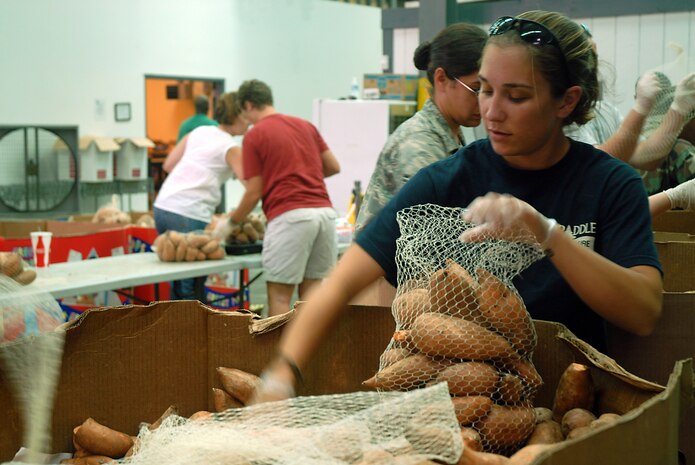 Senior Airman Michelle Emery bags sweet potatoes at the Lowcountry Food Bank, Charleston, S.C., Aug. 15.  More than 45 Airmen from the Charleston First 6 council bagged 11,000 pounds of potatoes that will be distributed to more than 250 families in the lowcountry.  Airman Emery is an aerial videographer with the 1st Combat Camera Squadron. (U.S. Air Force photo/Staff Sgt. Jennifer Arredondo)