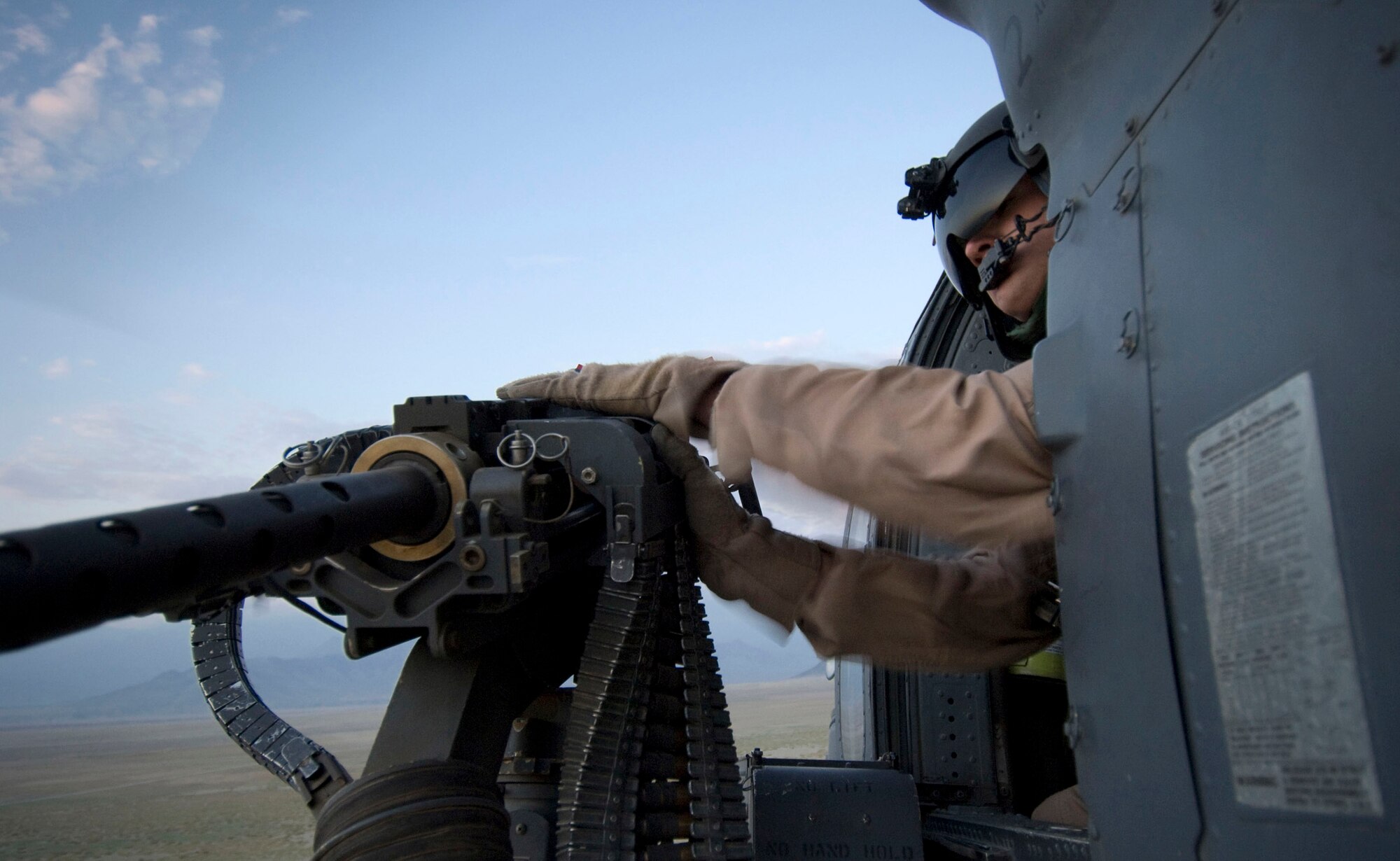 Senior Airman Ryan Ballinger, a 33rd Expeditionary Rescue Squadron gunner at Bagram Air Base, Afghanistan, checks out the 50-caliber machinegun on an HH-60G Pave Hawk Aug. 2 during a training flight. As an aerial gunner, Airman Ballinger provides security for combat search and rescue missions. He is deployed from the 33rd Rescue Squadron at Kadena AB, Japan. (U.S. Air Force photo/Staff Sgt. Samuel Morse)