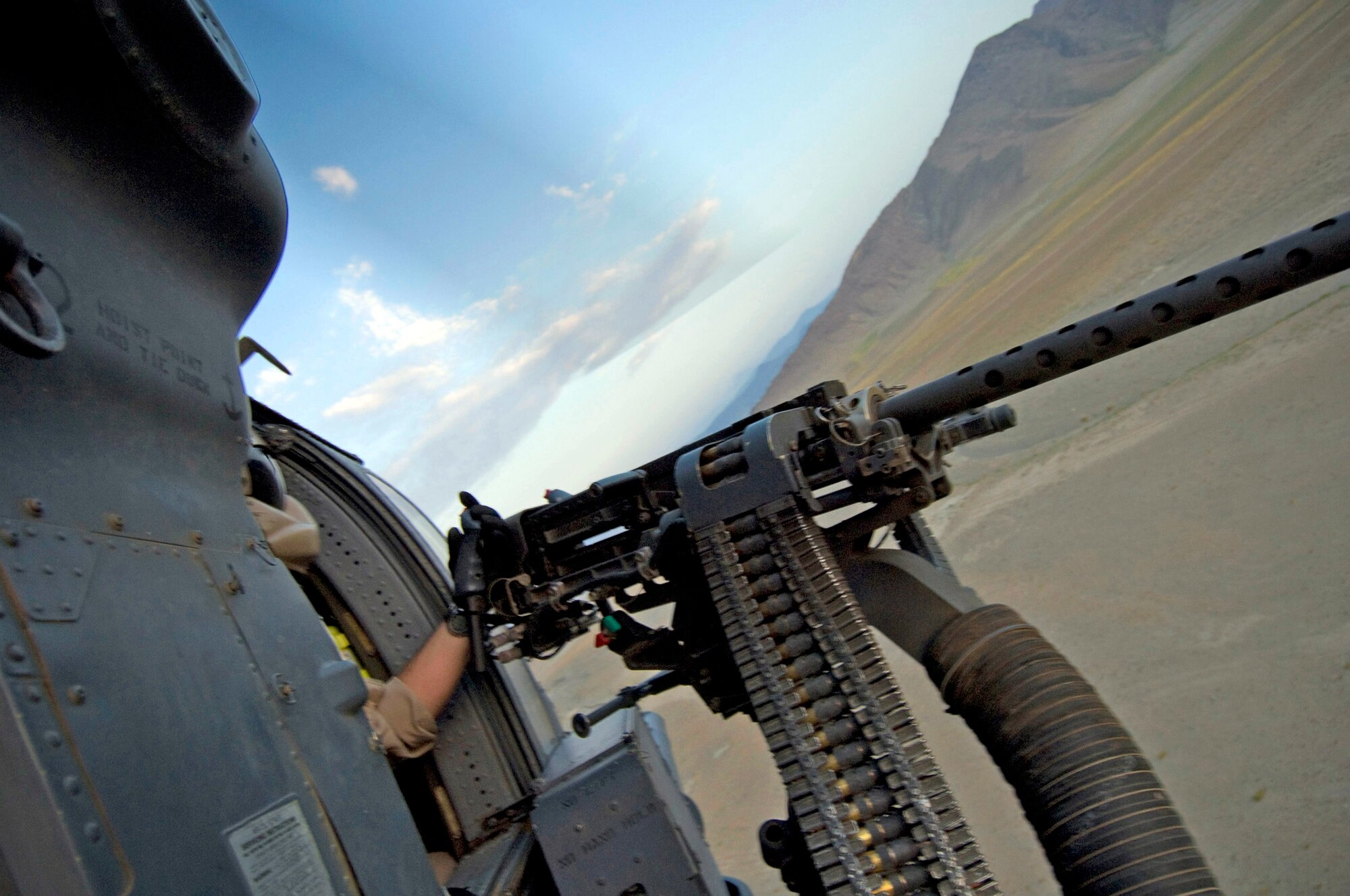 Staff Sgt. Gerald Messier checks out the 50-caliber machinegun on an HH-60G Pave Hawk  Aug. 2 at Bagram Air Base, Afghanistan, during a training flight.  Sergeant Messier is  a 33rd Expeditionary Rescue Squadron flight engineer at Bagram, and is deployed from the 33rd Rescue Squadron at Kadena AB, Japan. (U.S. Air Force photo/Staff Sgt. Samuel Morse)