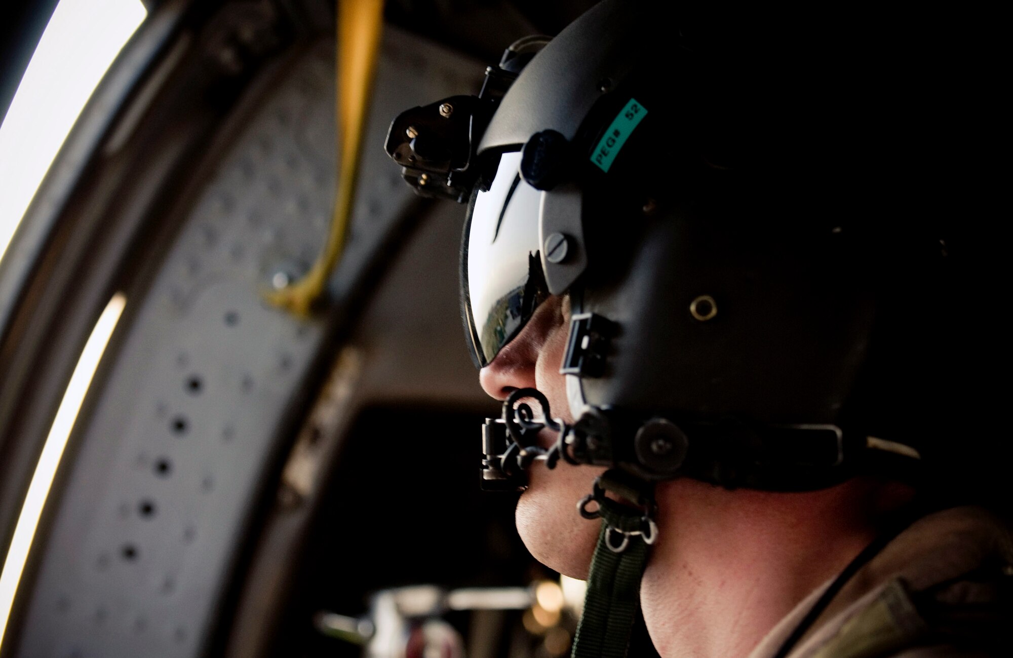 Senior Airman Ryan Ballinger, a 33rd Expeditionary Rescue Squadron gunner, looks out at Bagram Air Base, Afghanistan, Aug. 2 from his HH-60G Pave Hawk helicopter.  As an aerial gunner, Airman Ballinger is tasked with operating a 50-caliber machinegun and keeping a wary eye for enemy movement. He is deployed from the 33rd Rescue Squadron, Kadena AB, Japan. (U.S. Air Force photo/Staff Sgt. Samuel Morse)