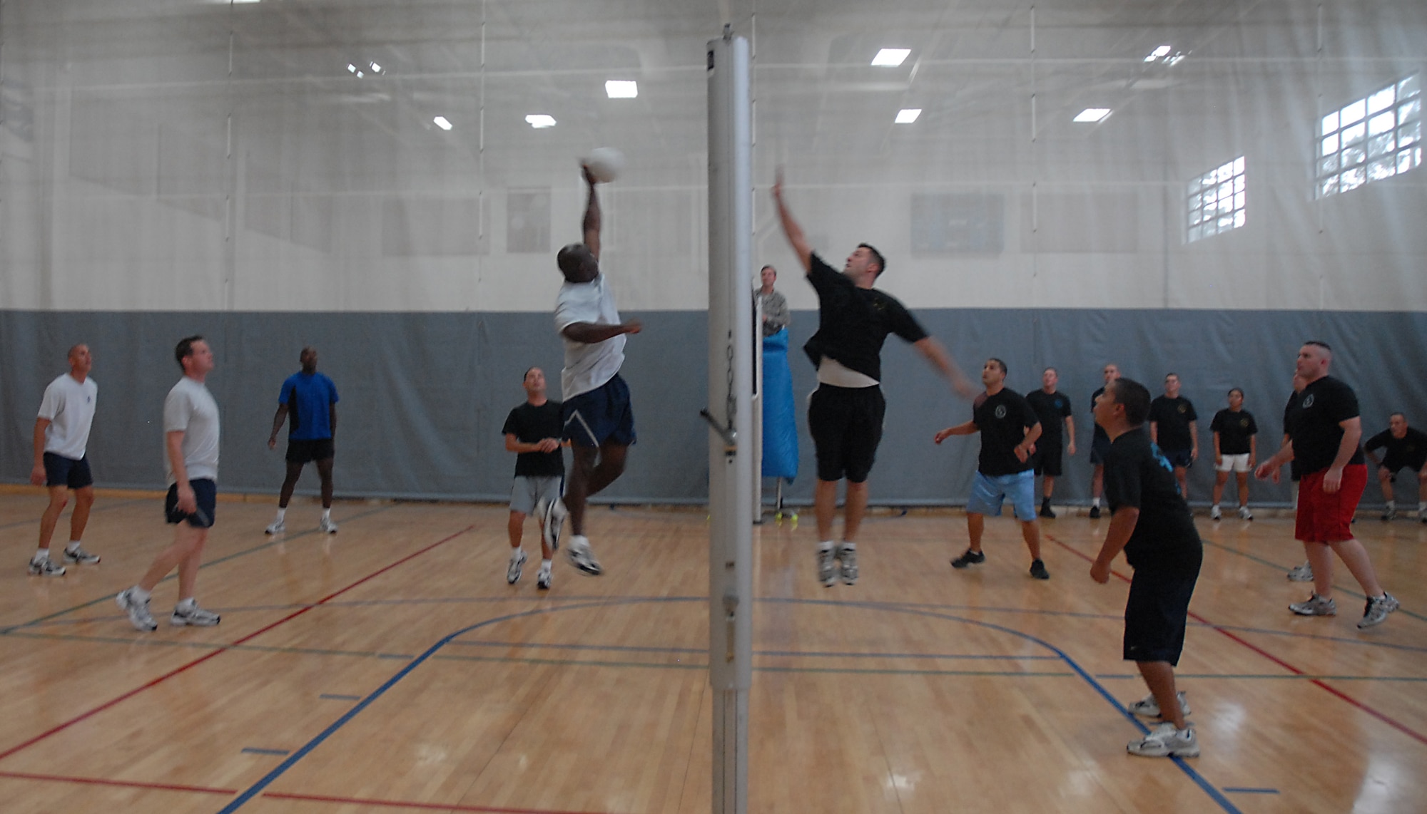 Rodney Koonce hits the ball to the Airman Leadership School team as Jesse Foor tries to block during a volleyball game on base Aug. 18. The Chiefs and Shirts team beat ALS 2-1. Koonce played for the Chiefs and Shirts from the 437th Force Support Squadron and Foor is with ALS from the 437th Aerial Port Squadron. (U.S. Air Force photo/Airman 1st Class Melissa White)