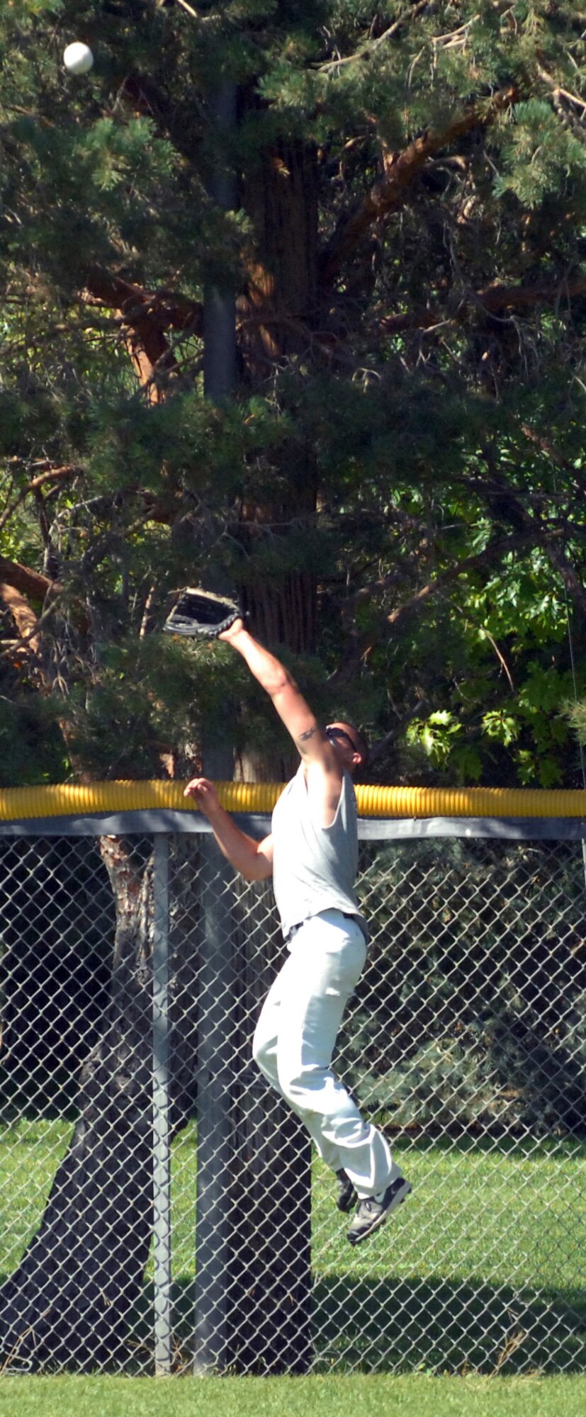 Scott Cote, National League outfielder, tried to scale the fence to save a homerun ball during the Mountain Home Air Force Base Intramural Softball All-Star game Aug. 14. The National League defeated the American League 15 – 14. (Photo by Airman 1st Class Ashley Winters)