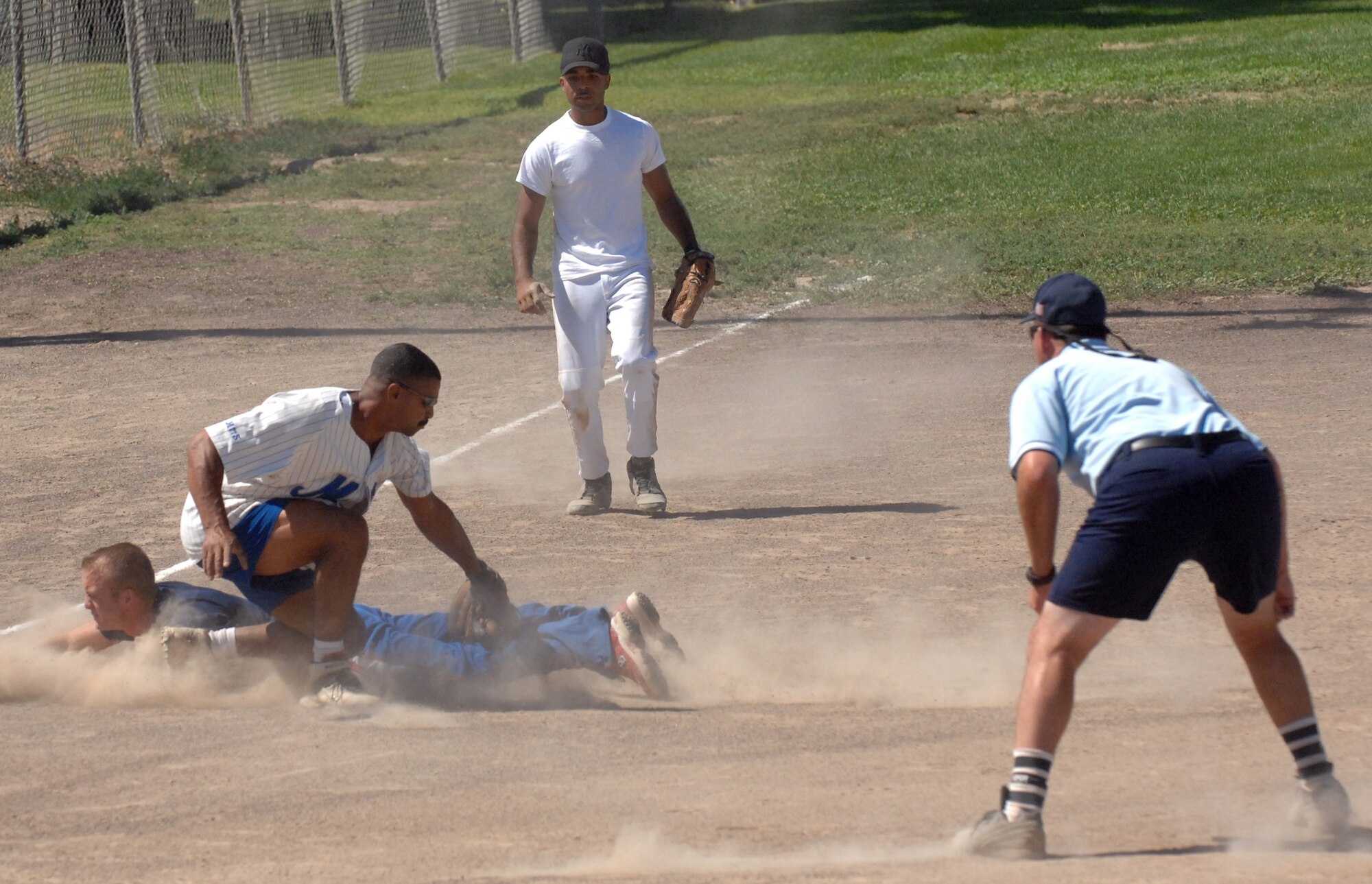 Mark Mitchell, National League second baseman, slides under the tag of Ramon Roman, American League pitcher, at third base during the Mountain Home Air Force Base Intramural Softball All-Star game Aug. 14. The National League defeated the American League 15 – 14. (Photo by Airman 1st Class Ashley Winters)
