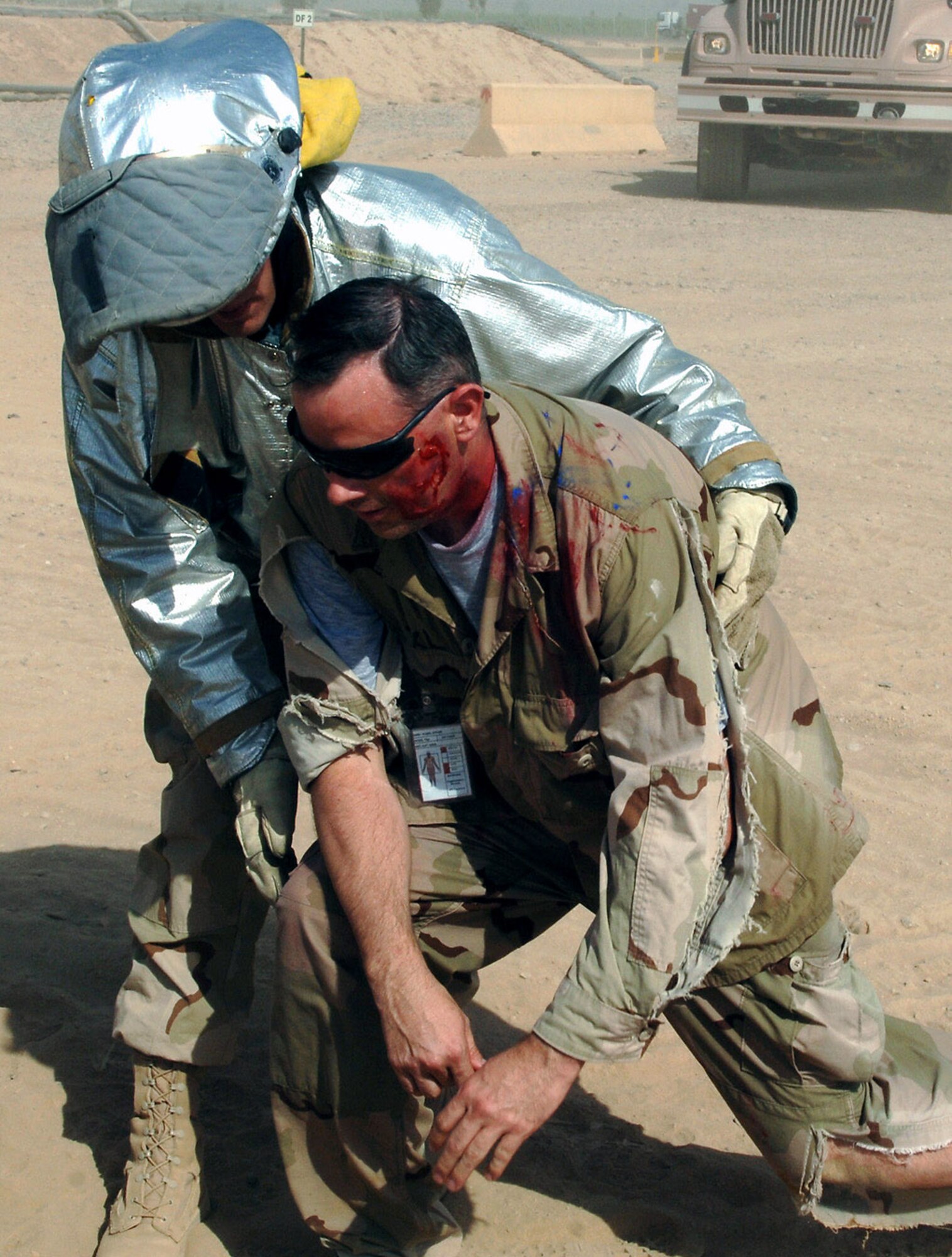 Airman 1st Class Troy Falkena assists injured participants during a mass accident response exercise Aug. 11 at Joint Base Balad, Iraq. More than 100 Airmen and Soldiers participated in the joint exercise ensuring first responders are ready for any situation at any time. Airman Falkena, a firefighter with the 332nd Expeditionary Civil Engineer Squadron here, is deployed from Langley Air Force Base, Va. (U.S. Air Force photo/Tech. Sgt. Richard Lisum) 
