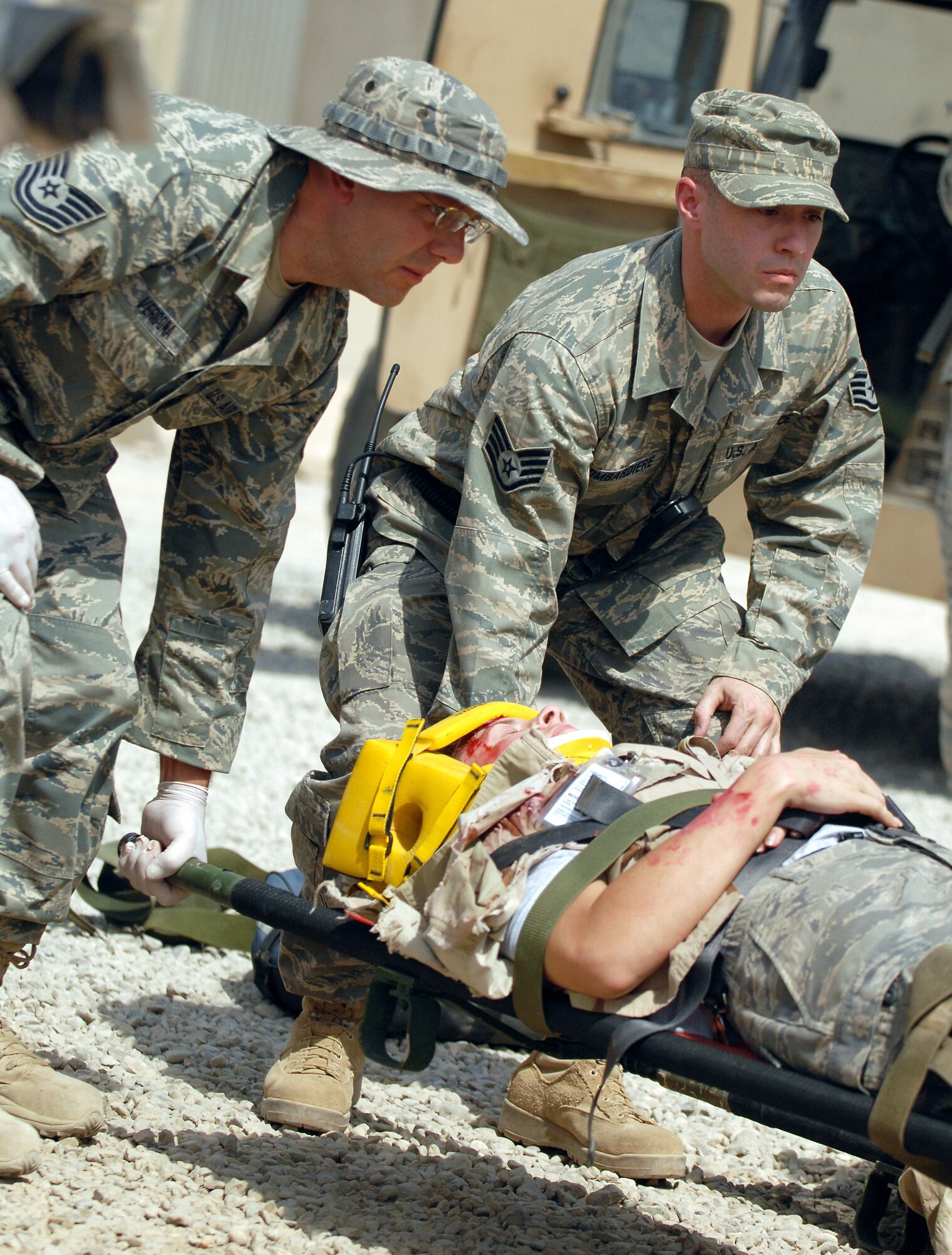 Tech. Sgt. Joseph Vergona and Staff Sgt. Salvatore Bombardiere carry a wounded servicemember on a stretcher during a mass accident response exercise Aug. 11 at Joint Base Balad, Iraq. More than 100 Airmen and Soldiers participated in the joint exercise ensuring first responders are ready for any situation at any time. Both NCOs are deployed to the Combat Aeromedical Staging Facility here from Pittsburgh International Airport Air Reserve Station, Penn. (U.S. Army photo/Staff Sgt. Les Newport) 
