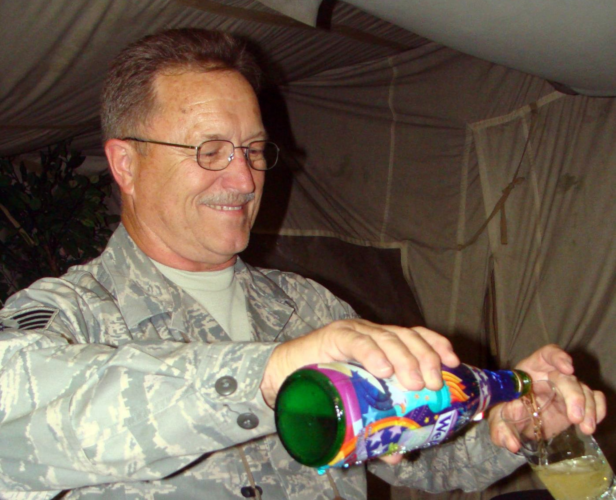 Staff Sgt. Albert Jensen is all smiles as he pours sparkling white grape juice following his marriage Aug. 8 to long-time sweetheart, Charlene Kehaualani Meyer, who is in Hawaii. The couple married through a double-proxy ceremony which spanned 16 time zones and 16,000 miles with the bride in Hawaii, chaplain in Montana, and groom in the Kyrgyz Republic. (Courtesy photo)                                                                                         
