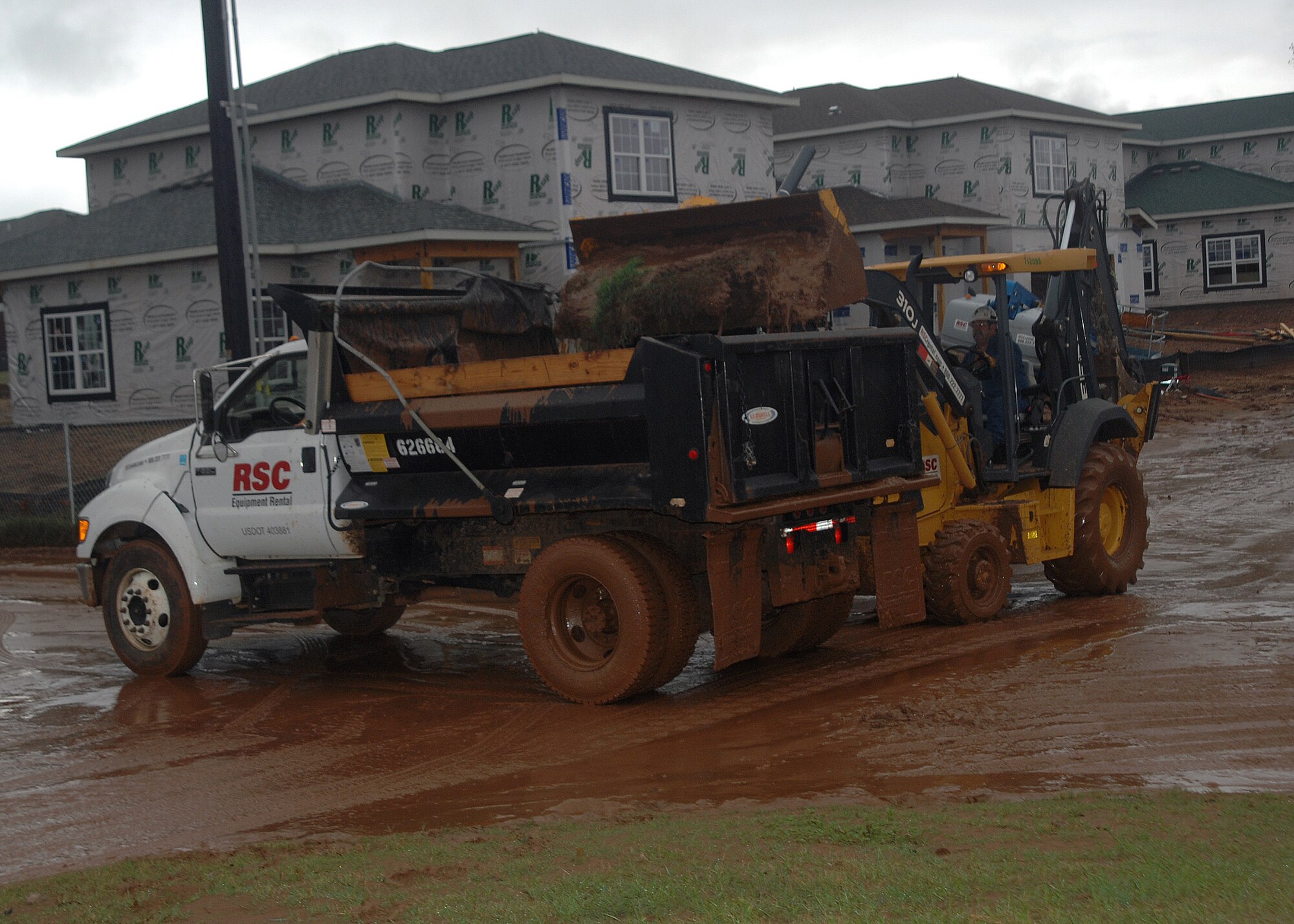 A contract employee empties a load of mud and debris Aug. 19 after heavy rains soaked Sheppard, flooding parts of the base. At least three families were evacuated from the new family base housing area Wind Creek Estates as flood waters entered their home. (U.S. Air Force photo/Lou Anne Sledge)
