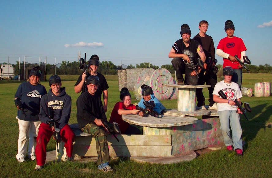 MINOT AIR FORCE BASE, N.D. – Staff Sgt. Eric Rader, 91st Missile Wing command chief executive assistant (camouflage pants) poses with a group of Quentin N. Burdick Job Corps Center students here following a paintball match Aug. 15. The paintball activity was just one of many ways the base continues to build its relationship with Job Corps. (Courtesy photo)