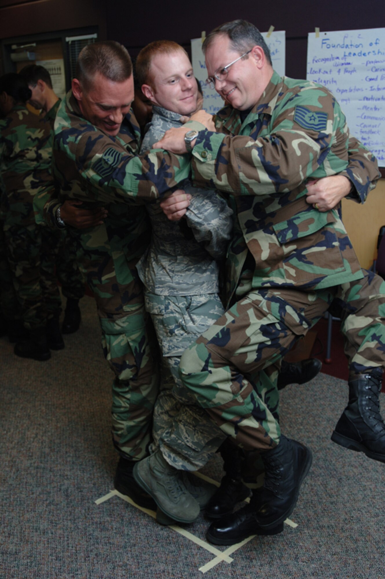 Staff Sgt. Neil Parks gets stuck in the middle of a team-building exercise with Tech. Sgt. Glen Pearson (left) and Tech. Sgt. Chris Crosser.  The exercise was part of a two-week Noncommissioned Officer Leadership Development Program course completed by 931st Air Refueling Group Airmen on Aug. 15. The three sergeants are assigned to the 931st Aircraft Maintenance Squadron. (U.S. Air Force photo/Tech. Sgt. Jason Schaap) 
