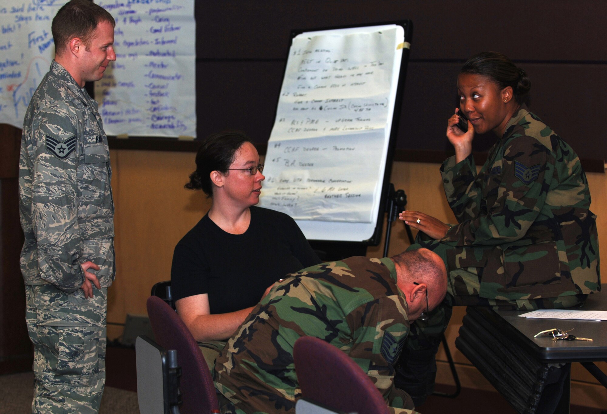 Staff Sgt. Evany Blanding is too busy with her cell phone to be bothered by her supervisor, played by Staff Sgt. Neil Parks (far left) during a role-playing scenario designed to help develop leadership.  The scenario was part of a two-week Noncommissioned Officer Leadership Development Program course completed by 931st Air Refueling Group Airmen on Aug. 15.  Sergeant's Parks and Blanding are assigned to the 931st Aircraft Maintenance Squadron.  The 931st Aerospace Medicine Squadron's Tech. Sgt. Kevin Schademann and Tech. Sgt. Cherry McCord also helped give Sergeant Parks a hard time during the skit. (U.S. Air Force photo/Tech. Sgt. Jason Schaap)