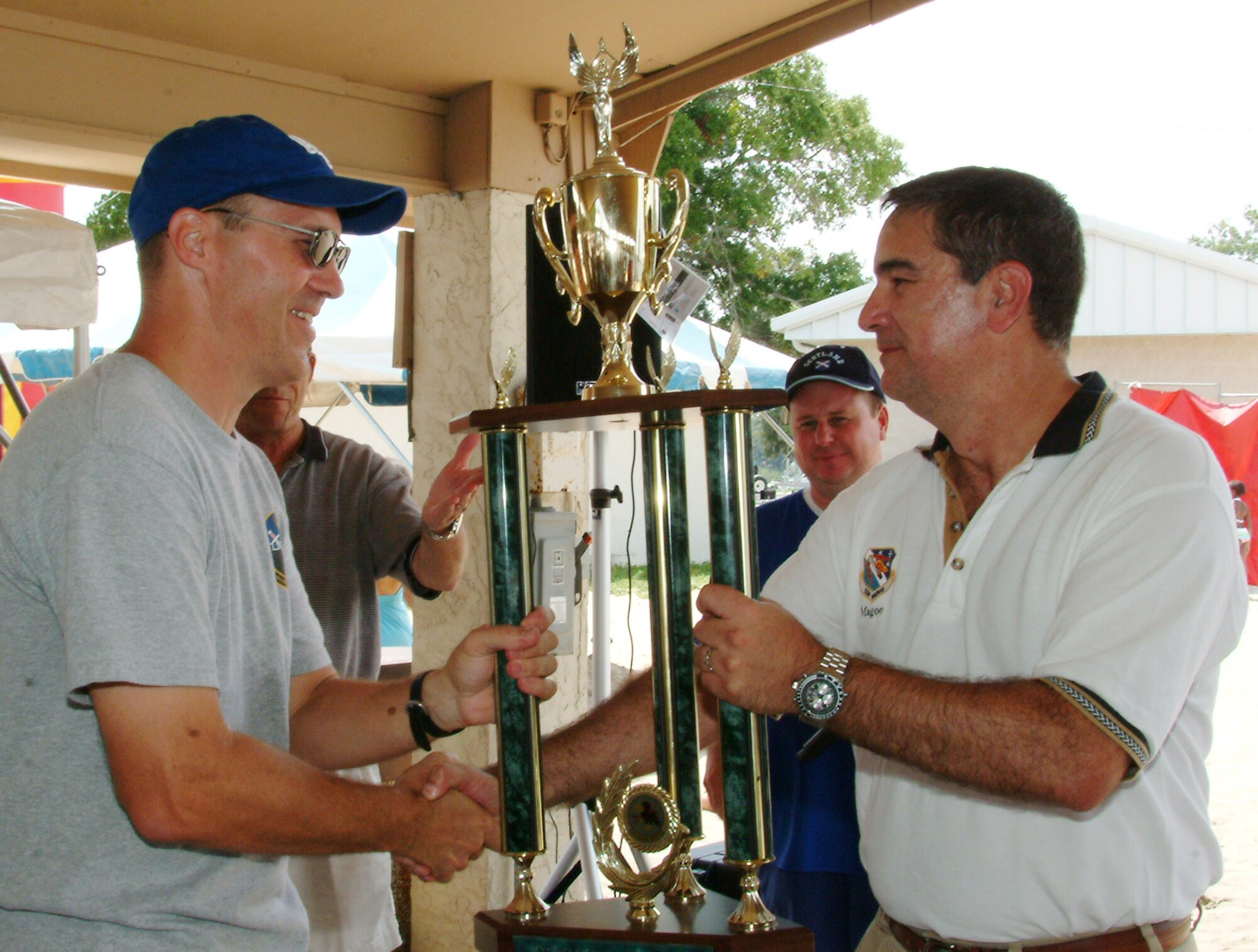 Lt Col Dean King, 16th Electronic Warfare Squadron, accepts the 1st place trophy from Col Mick Guthals, 53 Wing Vice Commander, during the Aug. 14 53d Wing Picnic at Post’l Point, Eglin Air Force Base, Fla.  The 16 EWS was the only unit to participate in every sporting event and scored almost two times as many points as the 2nd place team. Photo by Capt. Carrie L. Kessler.