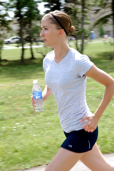 MINOT AIR FORCE BASE, N.D. – Senior Airman Kelly Timney, 5th Bomb Wing public affairs photographer, runs laps at the outdoor track here Aug. 13 as part of her training for the upcoming Air Force Marathon. Airman Timney is the only Airman from Minot AFB to be selected a member of Team Air Combat Command. (U.S. Air Force photo by Staff Sgt. Thomas Dow)