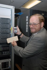 Thomas Maher, Air Education and Training Command chief technological officer, compares technology of old (a computer punch card from the 1970s that was used when he joined civil service) to a modern day blackberry. Mr. Maher will retire Aug. 28 after more than 33 years of civil service. (U.S. Air Force photo by Rich McFadden)