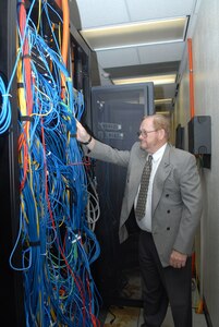 Thomas Maher, Air Education and Training Command chief technological officer, checks fiber optic wiring on a storage area network at the 12th Communications Squadron. Mr. Maher will retire Aug. 28 after more than 33 years of civil service. (U.S. Air Force photo by Rich McFadden)