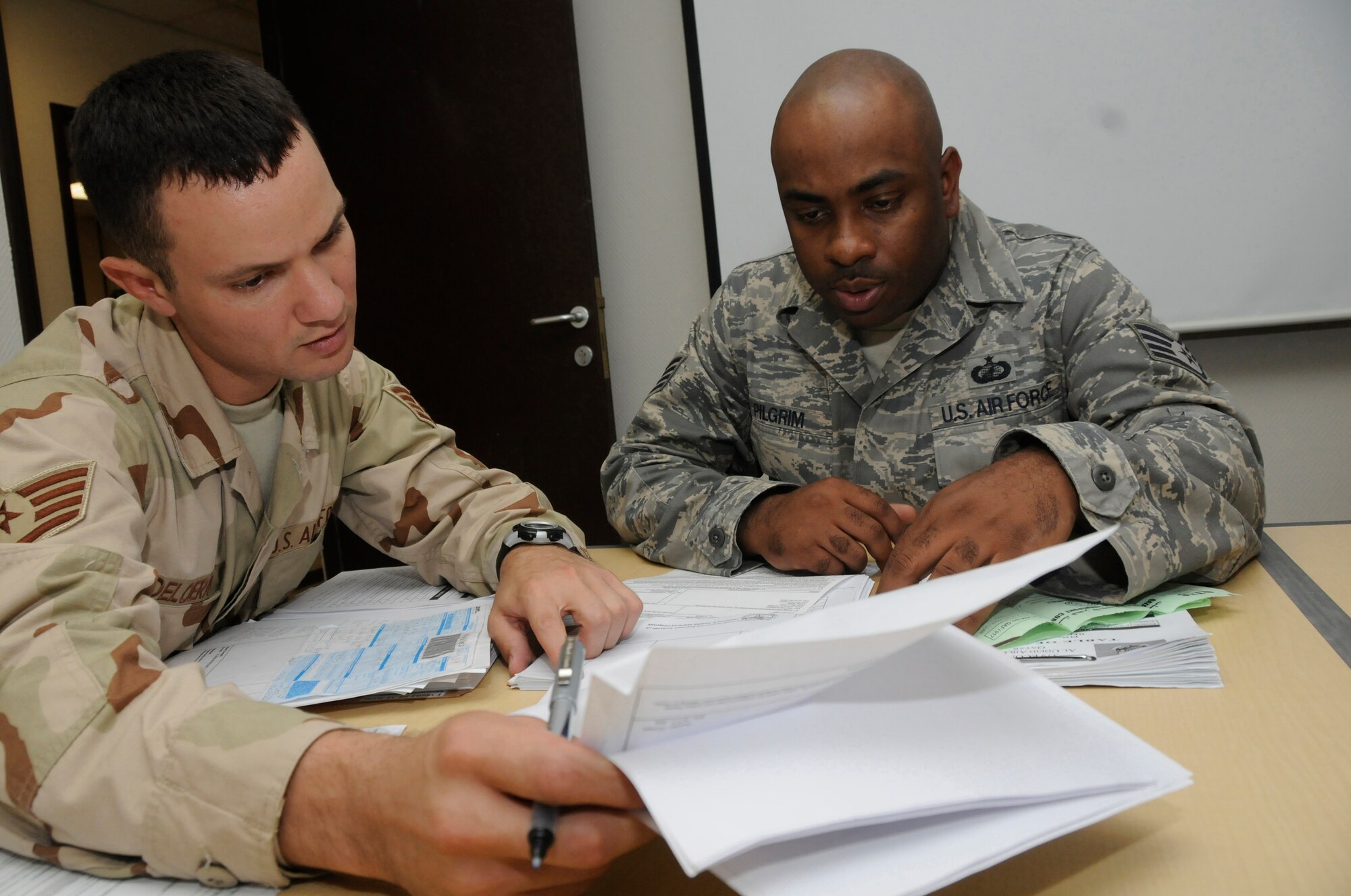 Staff Sgt. Scott DeLoera and Staff Sgt. Toine Pilgrim, both contracting officers with the 379th Expeditionary Contracting Squadron, review customs documents Aug. 18, 2008, at an undisclosed air base in Southwest Asia. Sergeant DeLoera, a native of Washington, D.C., is deployed from Anderson Air Base, Guam, and Sergeant Pilgrim, a native of Queens, N.Y., is deployed from McConnell Air Force Base, Kan., in support of Operations Iraqi Freedom, Enduring Freedom and Joint Task Force-Horn of Africa. (U.S. Air Force photo by Staff Sgt. Darnell T. Cannady/Released)
