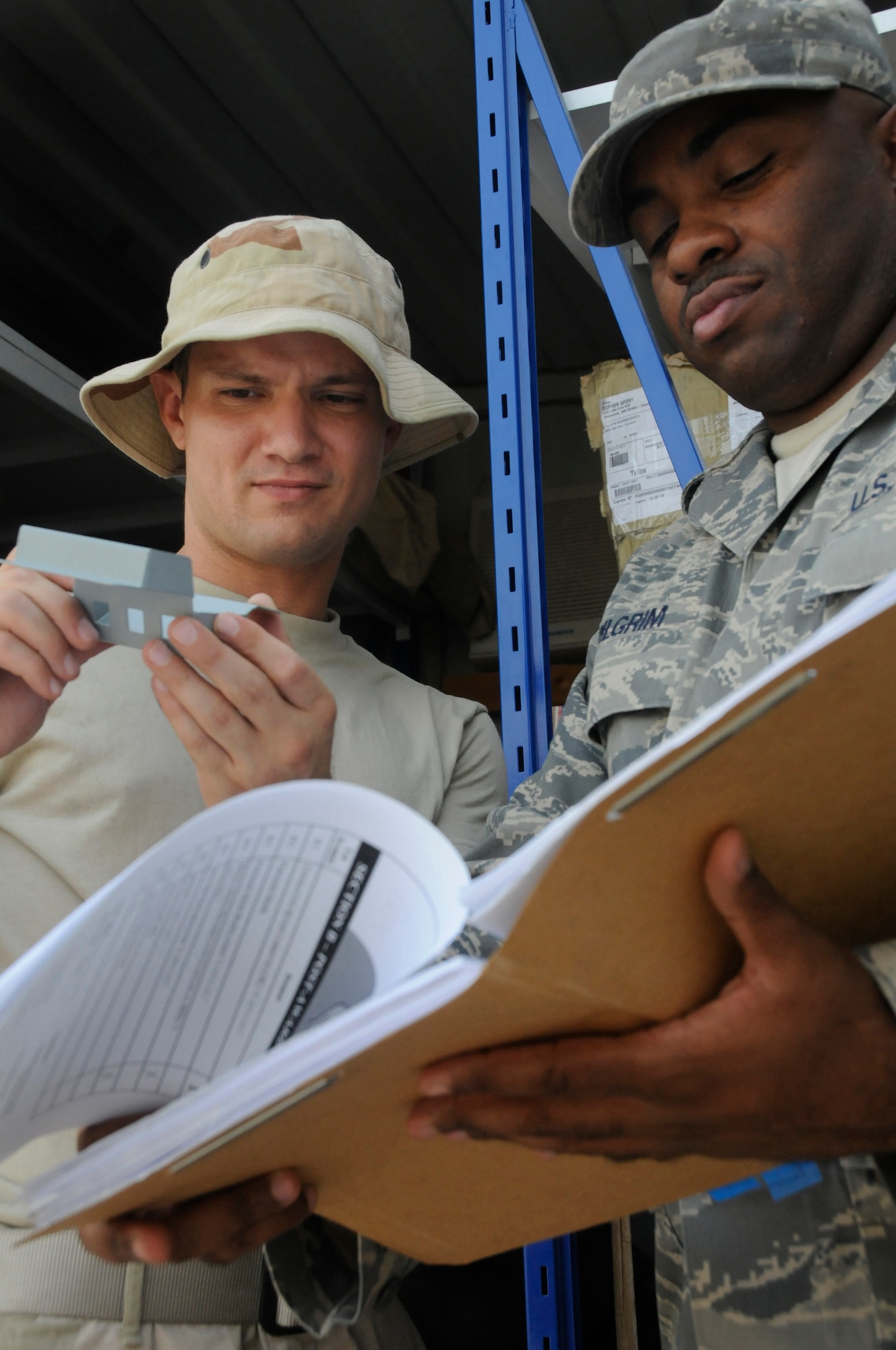 Staff Sgt. Scott DeLoera inspects a shipment of commodities while Staff Sgt. Toine Pilgrim verifies it against the contract Aug. 18, 2008, at an undisclosed air base in Southwest Asia. Both Sergeant DeLoera and Sergeant Pilgrim are contracting officers assigned to the 379th Expeditionary Contracting Squadron. Sergeant DeLoera, a native of Washington, D.C., is deployed from Anderson Air Base, Guam, and Sergeant Pilgrim, a native of Queens, N.Y., is deployed from McConnell Air Force Base, Kan., in support of Operations Iraqi Freedom, Enduring Freedom and Joint Task Force-Horn of Africa. (U.S. Air Force photo by Staff Sgt. Darnell T. Cannady/Released)