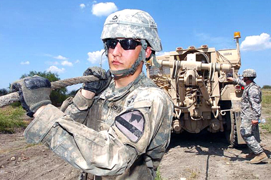 U.S. Army Pfc. Justin Coley, a metal worker, pulls out a wench cable during vehicle recover training on Fort Hood, Texas, Aug. 14, 2008. The soldiers are assigned to the  1st Cavalry Division's Company B, 15th Brigade Support Battalion.  