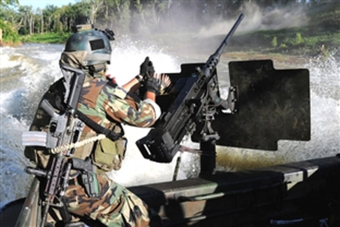 A U.S. Navy sailor serving as a special warfare combatant-craft crewman reloads a machine gun while conducting live-fire drills at the riverine training range on Fort Knox, Ky., Aug. 11, 2008. 