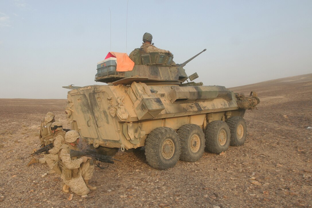 Al QATRANAH, Jordan, (Aug. 19, 2008) -- Scouts with the Light Armored Vehicle platoon, 15th Marine Expeditionary Unit take cover behind an LAV prior to beginning a trench assault in Jordanian desert during "Operation Infinite Moonlight." For the LAV platoon the purpose of the training was to refine basic infantry tactics such as trench assaults, weaponry skills, ambush training and a gunnery skills with the LAV's main cannon.  The Camp Pendleton, Calif., based  15th MEU  is comprised of approximately 2,200 Marines and Sailors and is a forward deployed force in readiness capable of conducting numerous operations, such as Non-Combatant Evacuation Operations, Humanitarian Assistance Operations and range of  amphibious missions. The MEU is currently deployed aboard USS Peleliu (LHA-5), USS Dubuque (LPD-8) and USS Pearl Harbor (LSD-52). (Official USMC photo by Cpl. Stephen Holt)(Released)::r::::n::