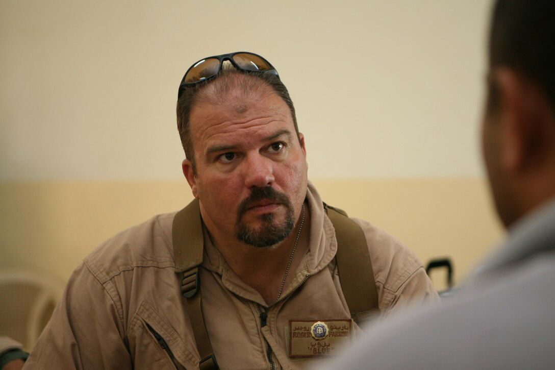 Roger Parrino, a law enforcement professional with 3rd Battalion, 4th Marine Regiment, Regimental Combat Team 5, questions a suspected insurgent Aug. 20 in Hit, Iraq. Parrino, 47, from New York City, assists the battalion with criminal investigations. His responsibilities include making cases against insurgents and mentoring the National Intelligence and Investigation Agency, which acts like a local FBI in Hit.  Parrino has 21 years of law enforcement experience that he uses to assist Coalition forces.