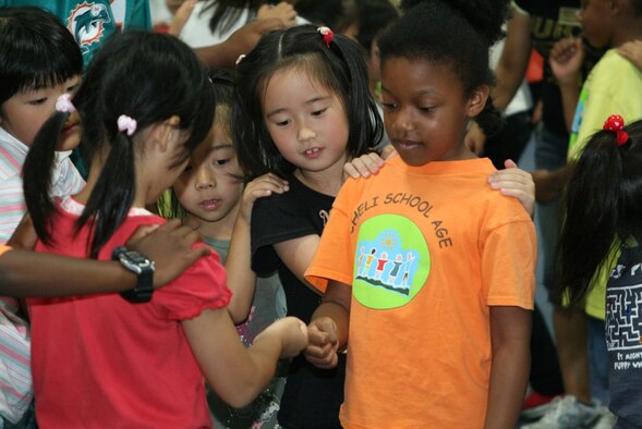 MISAWA AIR BASE, Japan -- Quintya Whitfield, 7, daughter of Tech. Sgt. Calandro Whitfield, 373rd Support Squadron, plays "rock, paper, scissors" with a Japanese student from an Aomori elementary school during a visit to the Weasels' Den Aug. 7, 2008.  American and Japanese children played a variety of other games including an egg relay and a three-legged race during a bi-lateral event to encourage cultural and friendship exchange.  (U.S. Air Force photo by Abigail Douglass) 