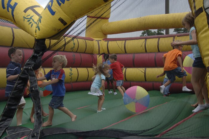 Children play in an inflatable castle at the operational readiness inspection picnic Aug. 15 at the Charleston Club while Airmen celebrate a job well done for the ORI. The 437th Airlift Wing received an ?Excellent? rating. The Air Mobility Command Inspector General?s office recognized more than 32 Airmen and Department of Defense civilians for their efforts during the ORI and more than 15 special teams for outstanding performance during the inspection. (U.S. Air Force photo/Airman 1st Class Timothy Taylor) 