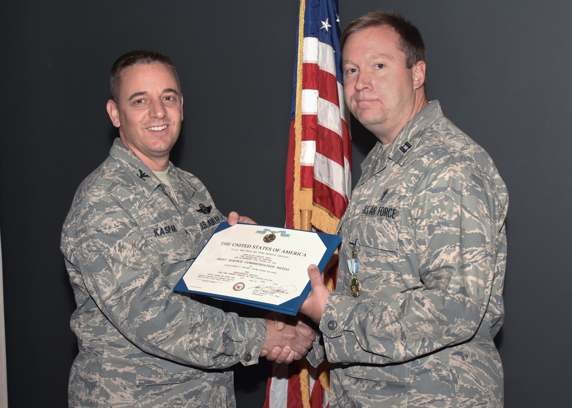 CANNON AIR FORCE BASE, N.M. -- Col. Hans Kaspar, 27th Special Operations vice wing commander, presents Capt. Donald Bridges, 27th Special Operations Wing Chapel, the Joint Service Commmendation Medal Aug. 19 during the wing staff meeting. Captain Bridges was recognized for his joint-service contributions while stationed in Iraq. (U.S. Air Force photo by Airman 1st Class James R. Bell)
