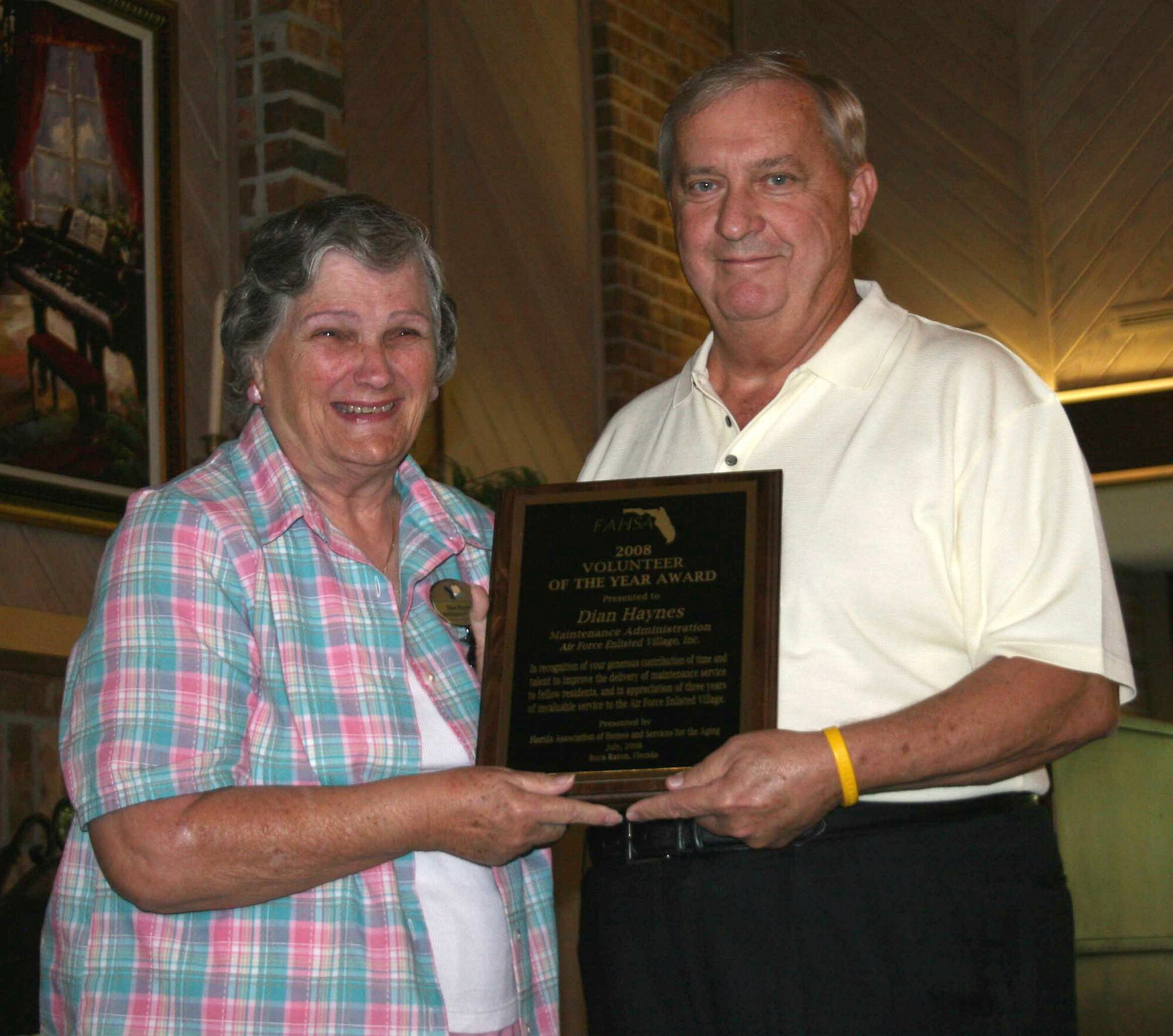 Air Force Enlisted Village President and CEO James C. Binnicker presents Dian Haynes with the Florida Association of Homes and Services for the Aging Volunteer of the Year award. (Courtesy photo/Cathy S. Landroche)
