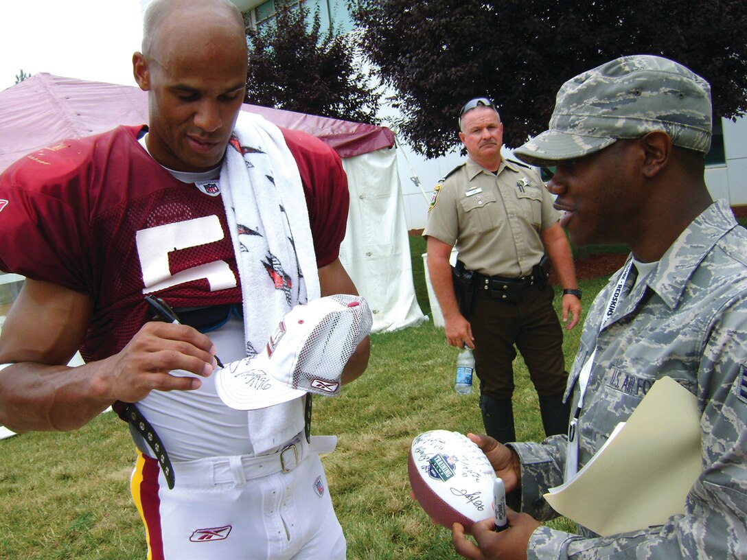 Jason Taylor, Washington Redskins defensive end, signs an autograph for Senior Airman Arnez Smith, Air Force District of Washington, July 23. A group of Andrews Airmen were invited to Redskins Park in Loudon County, Va., to watch the team practice for the 2008-2009 season. The Airmen were also given a tour of the Redskins training facility.